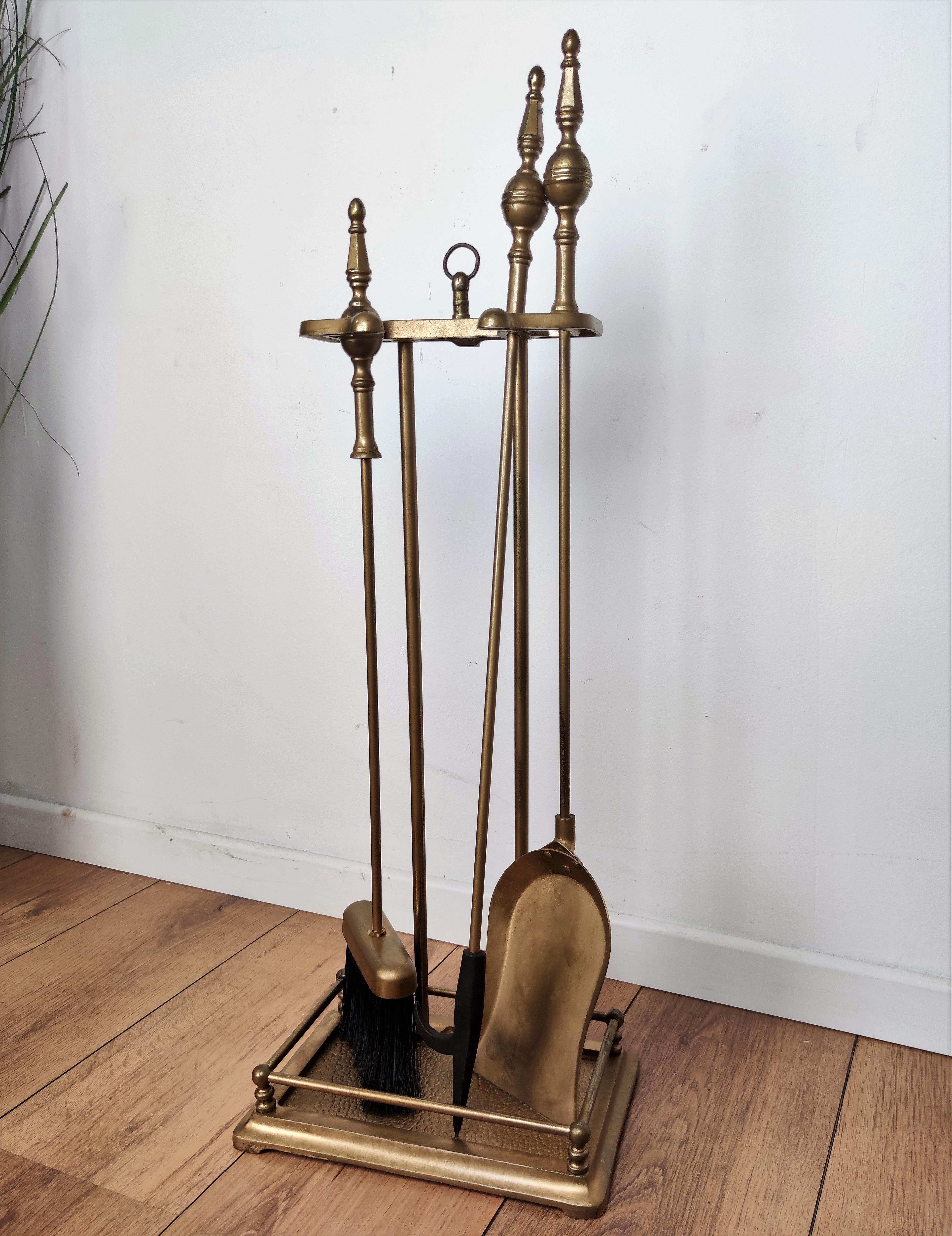 Italian brass three-piece fire tool set with stand. The set consists of a poker, a shovel and a pair of tongs, each with an ornate acorn handle such as the stand.