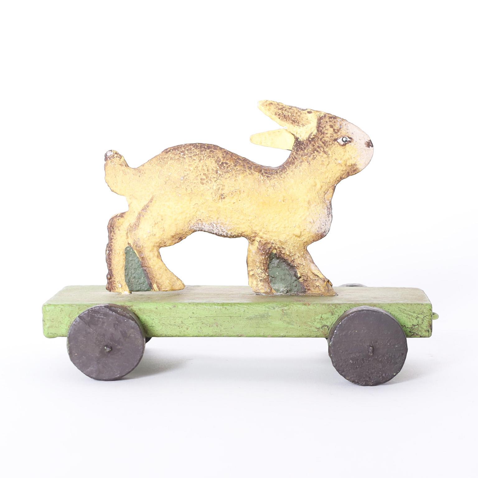 Vintage three piece child's circus train toys featuring a lion, a monkey riding a dog, and a rabbit crafted in metal and hand painted, riding on wooden cars in a simple time and place. Can be available individually, please inquire for more details.