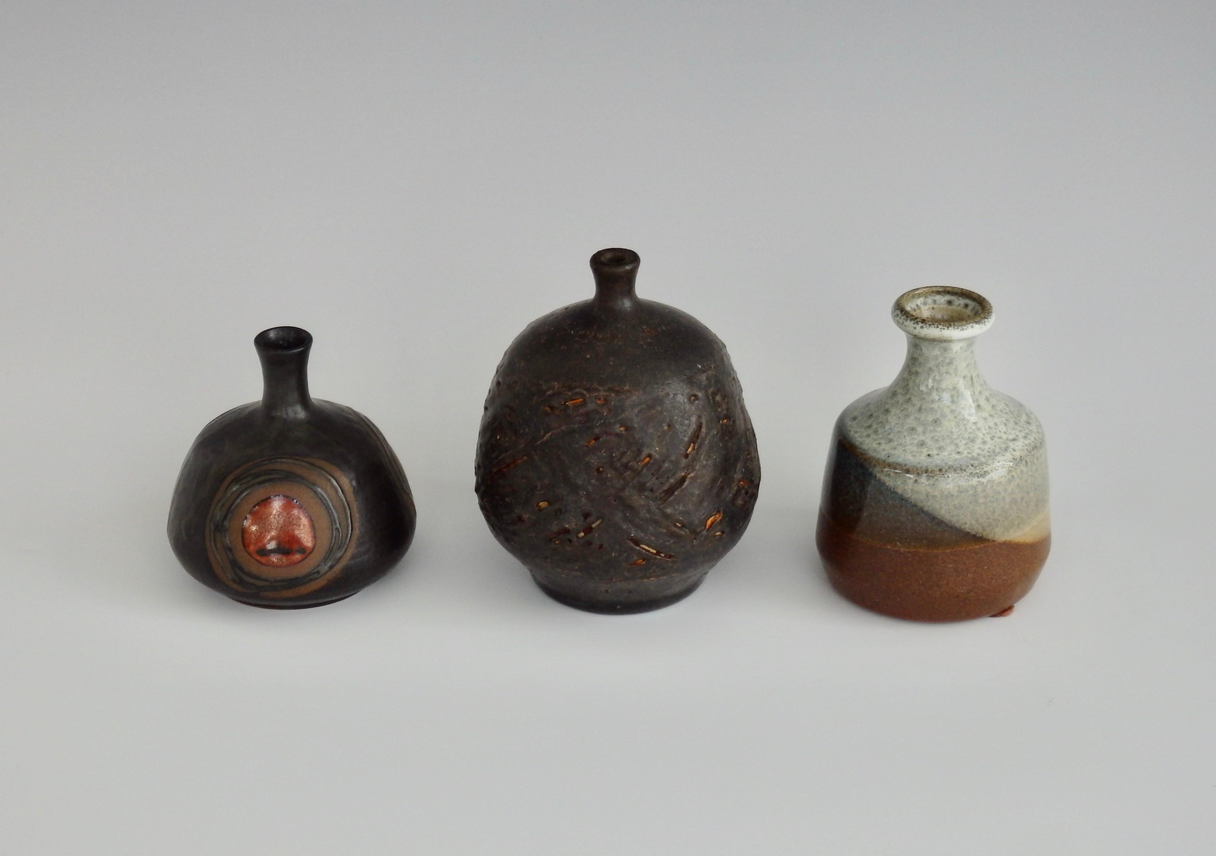 This three-piece collection of diminutive vessels includes an Otagiri Japan brown and orange glazed weed pot with concentric circles (label intact), a visually textural weed pot in multicolored glaze, and a texturized brown glazed weed pot