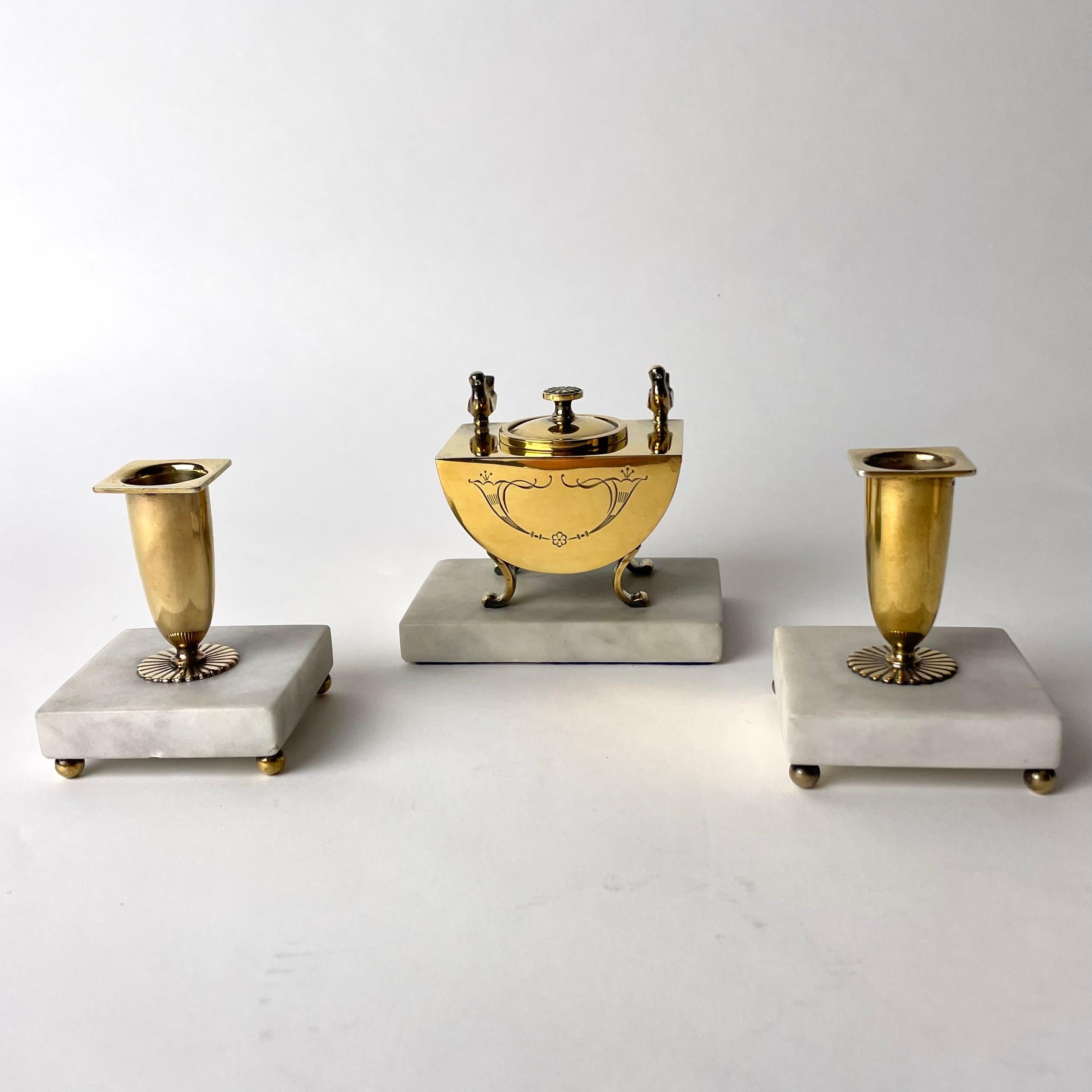 A beautiful Three-piece Desk Set in gilded silver. Very period Swedish Grace from CG Hallbergs in Stockholm, Sweden dated 1929 by Swedish hallmarks. An elegant gilded silver inkstand standing on a Carrara base and a pair of matching gilded silver