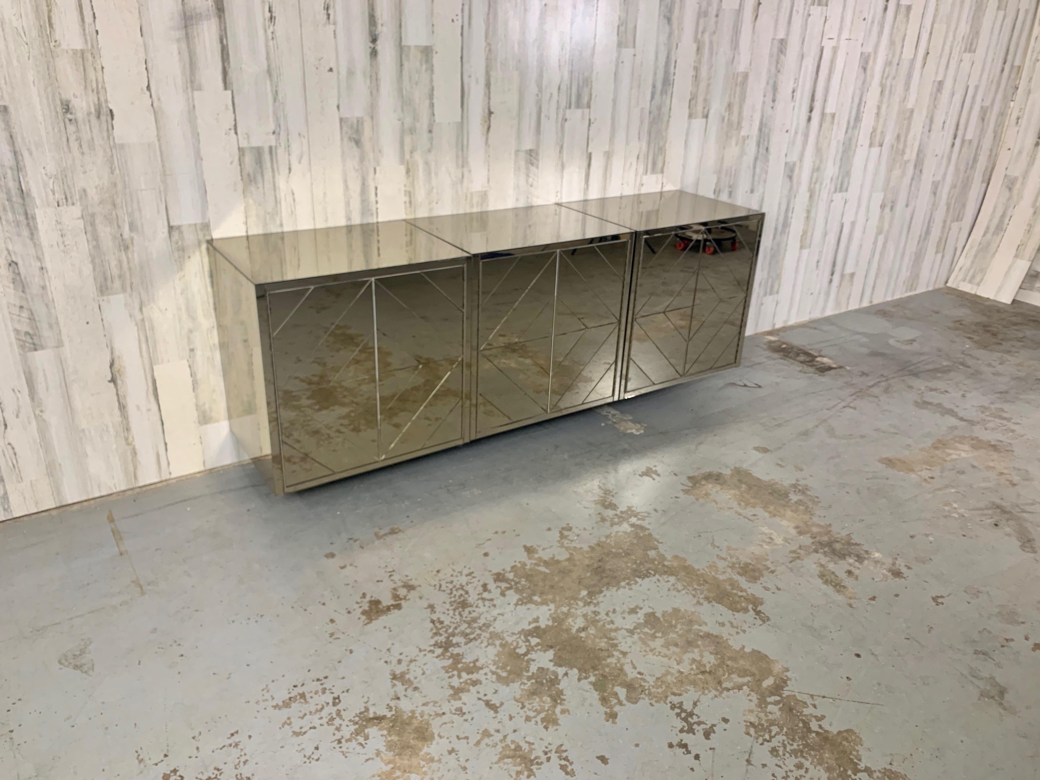 Mirrored Diamond pattern floating credenza. These pieces can be hung together or separated into any configuration. They can also be hung at any hight making them very versatile for any space. This fully mirrored credenza has a very 1970s look. There