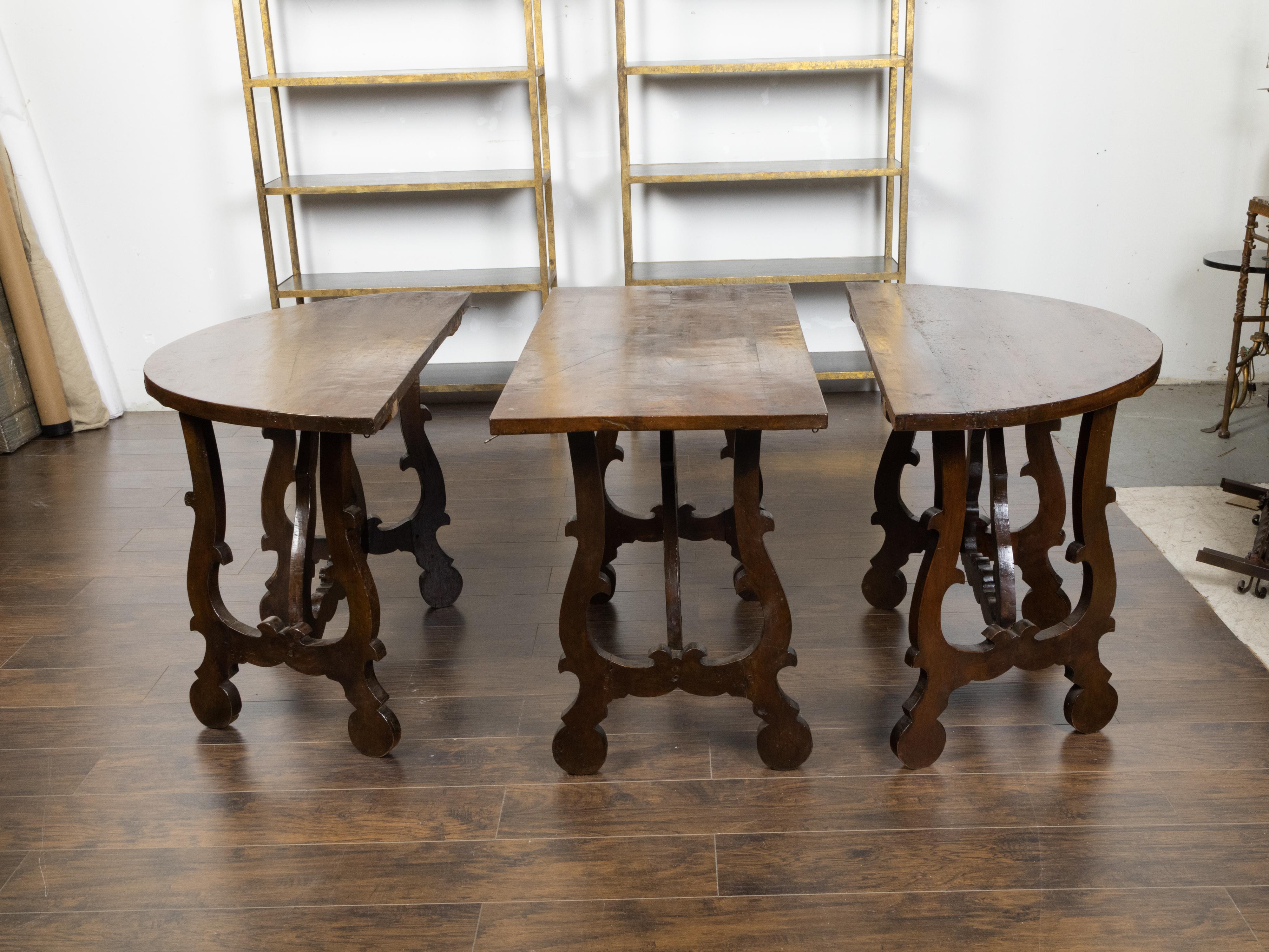 A three-piece Italian Baroque style oval top wooden table from the early 19th century, made of a side table, a pair of demilunes and lyre-shaped legs. Created in Italy during the first quarter of the 19th century, this Italian Baroque style table