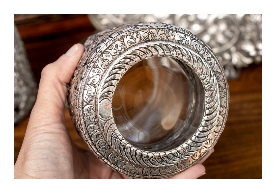 An oval bowl with deep repousse decoration of foliate scrolls with flowers alternating with palmettes, with a dark patina in the background. The inside hand hammered around a leafy surround of the center. 
Measures: Length 11 1/2