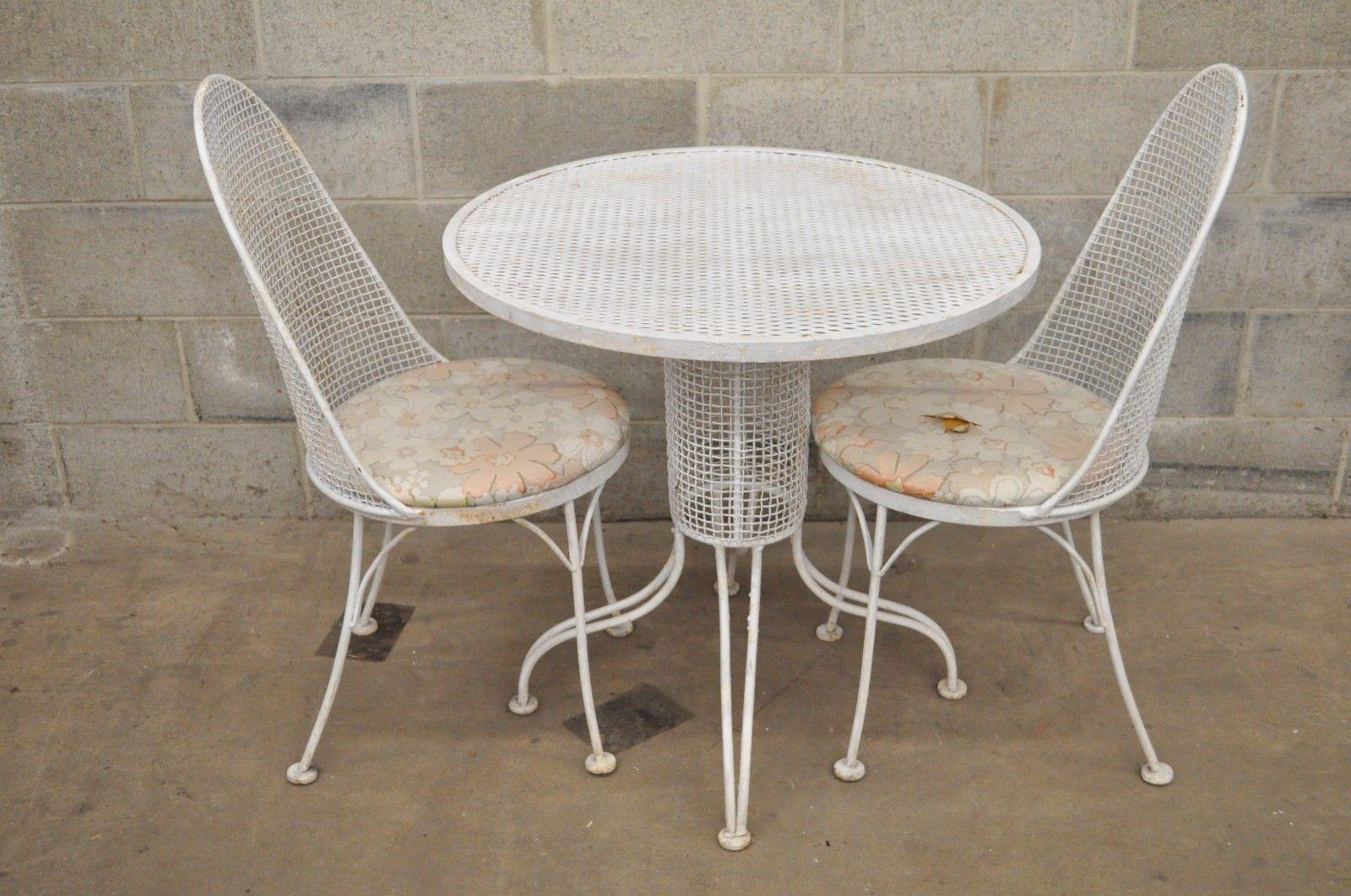 Very rare vintage three-piece iron metal mesh patio bistro dining set believed to be Russell Woodard. Item features iron metal mesh construction, round pedestal base dining table, two dining side chairs, round seats, oval backs, great modernist