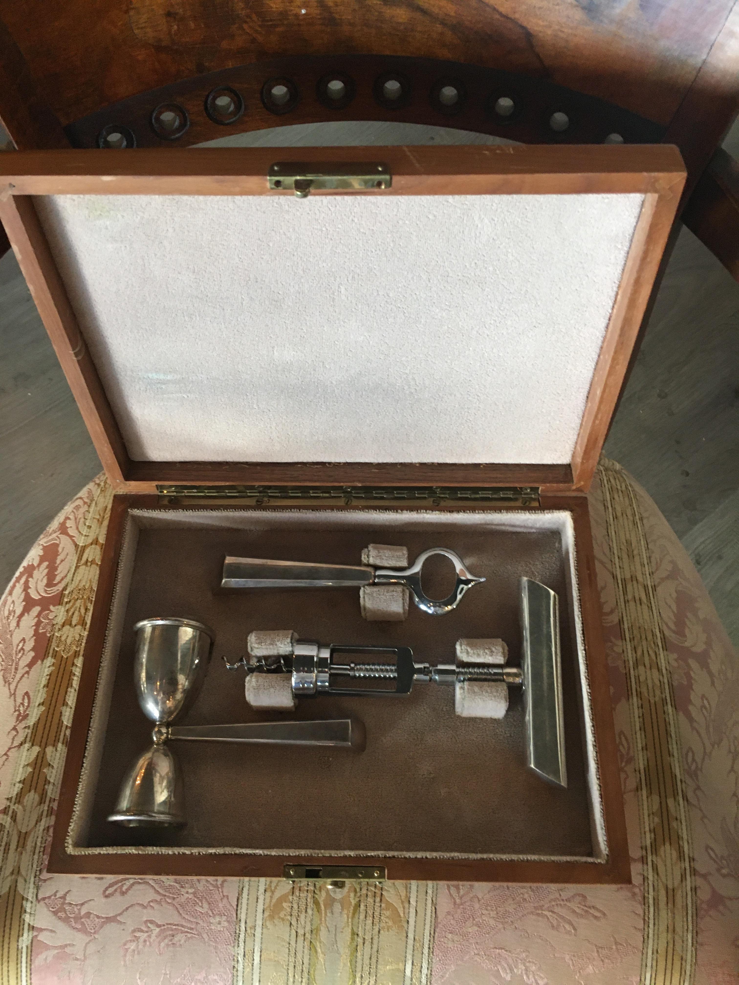 An exceptional Art Deco sterling silver bar set manufactured by New York silversmith John Hasselbring.  The fitted walnut case includes a six piece set comprised of includes corkscrew, bottle opener, spirit measure, all marked sterling. 

Circa