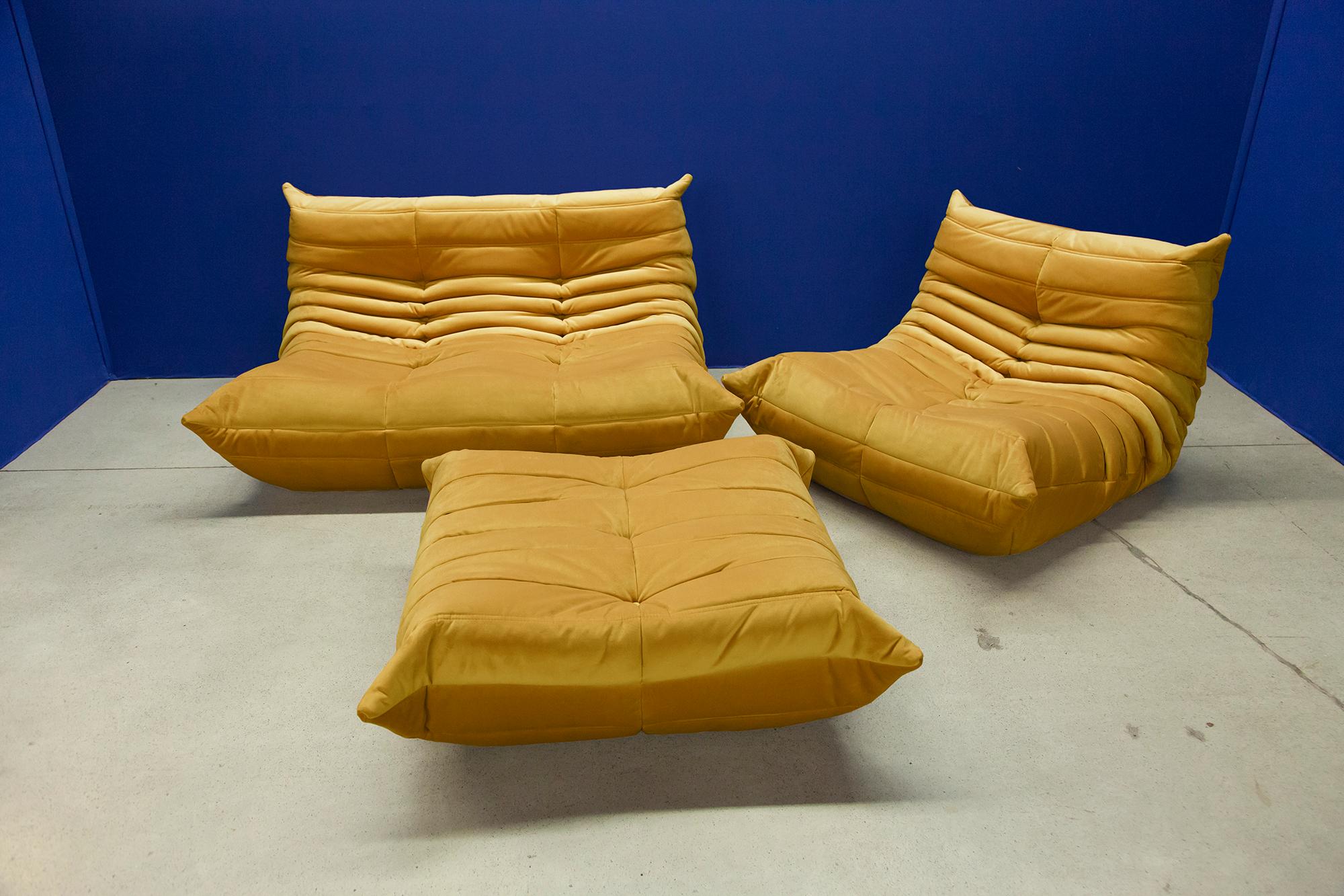 This Togo living room set was designed by Michel Ducaroy in 1974 and was manufactured by Ligne Roset in France. It has been reupholstered in golden yellow high quality velvet, and is made up of the following pieces, each with the original Ligne