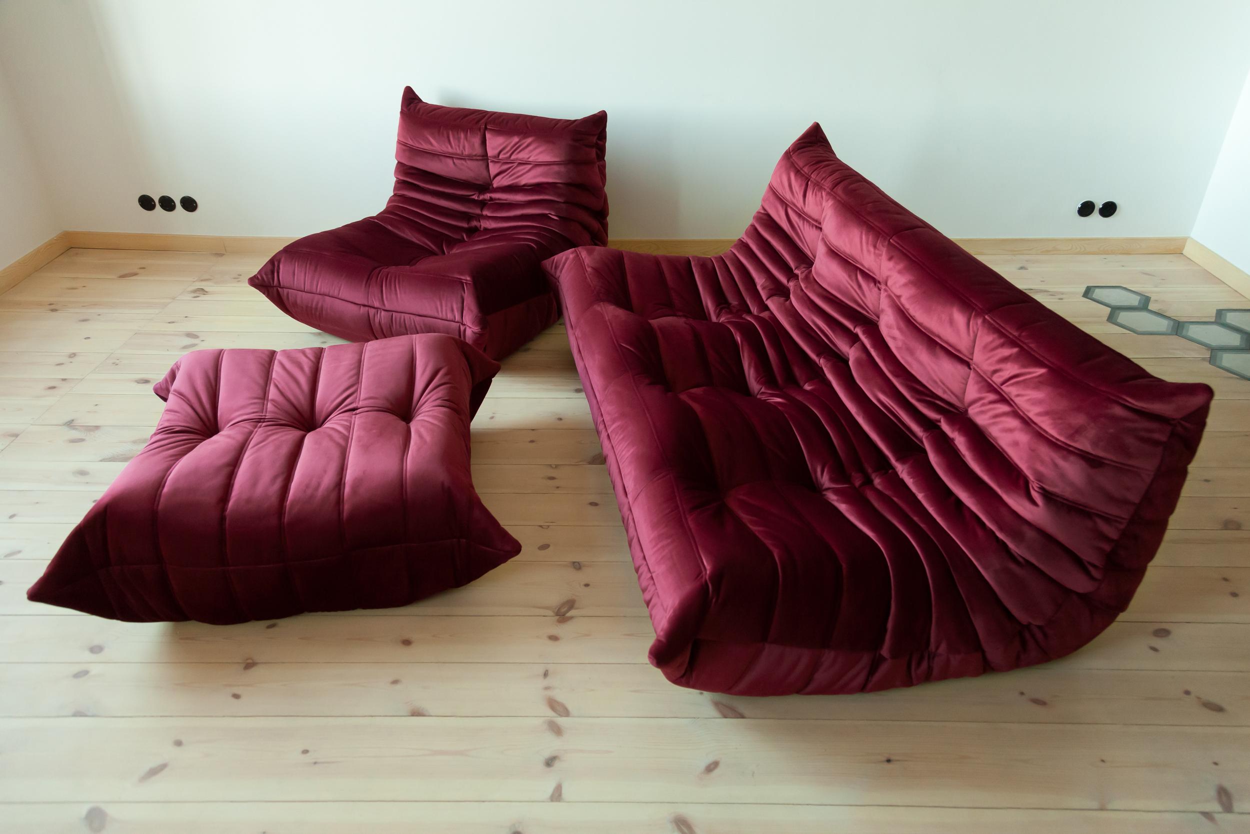 Three-piece Togo set, Design by Michel Ducaroy, manufactured by Ligne Roset this Togo living room set was designed by Michel Ducaroy in 1974 and was manufactured by Ligne Roset in France. It has been reupholstered in burgundy high quality velvet,