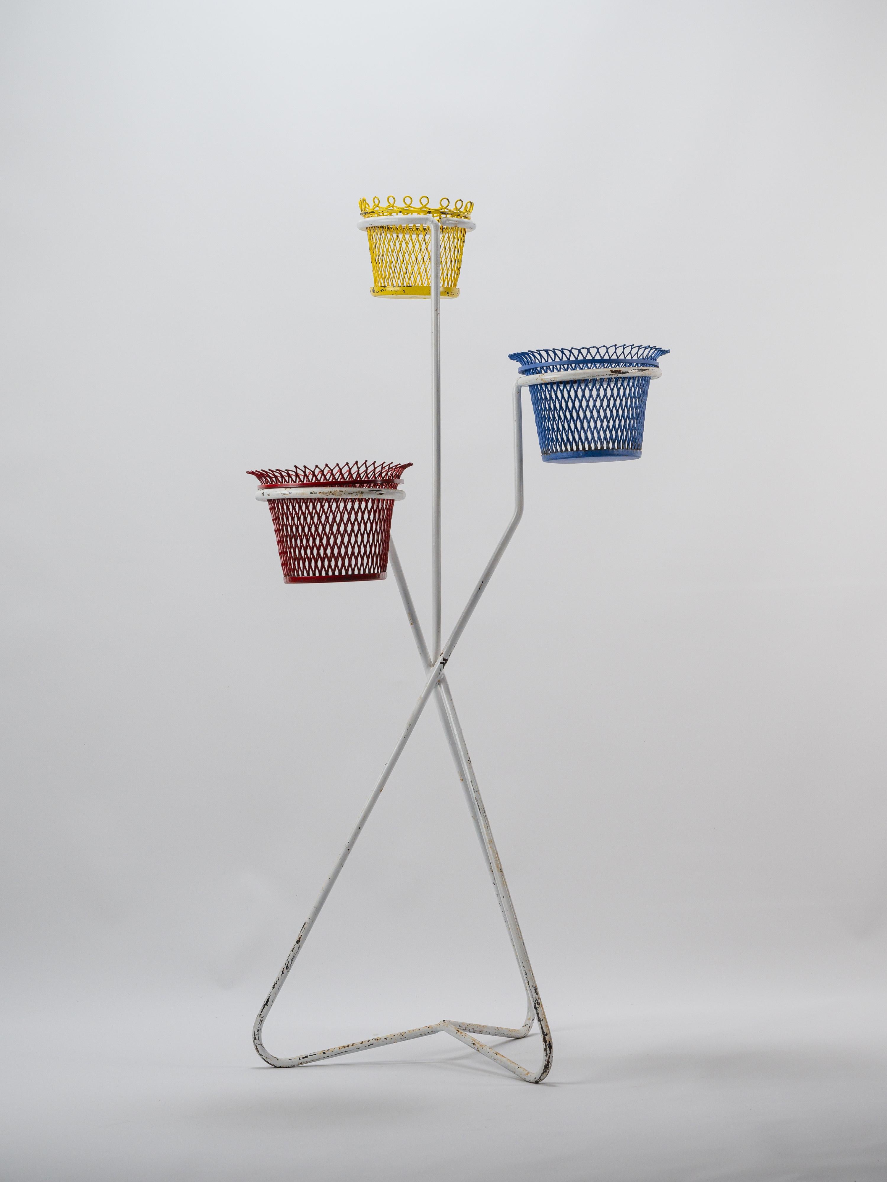 Cet élégant cache-pot du milieu du siècle a été conçu par Mathieu Matégot dans les années 1950. Fabriqué en métal, il comporte trois cache-pots distincts, chacun fabriqué à partir de tôle perforée dans des couleurs primaires vibrantes - jaune, rouge