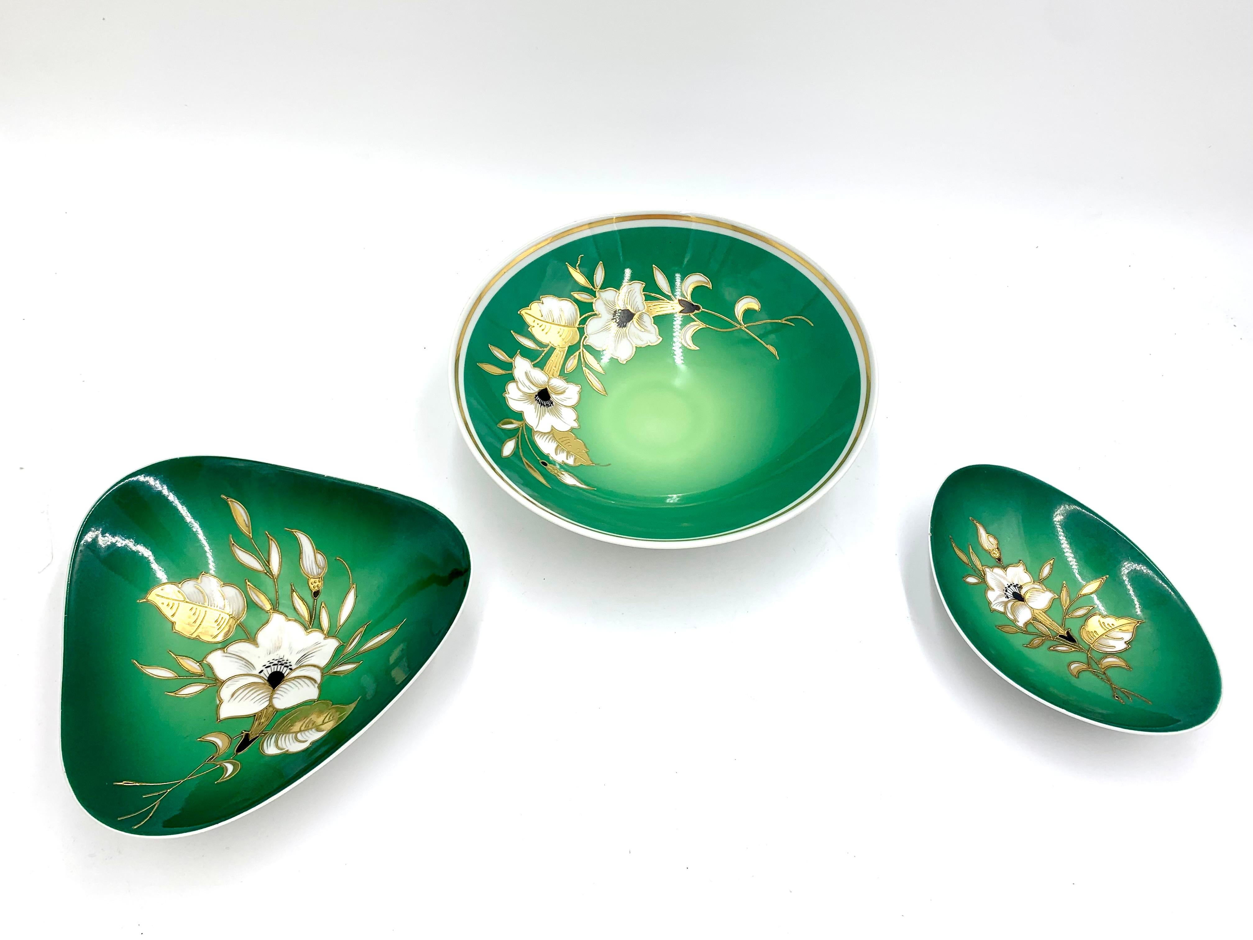 Three porcelain dishes made in Thuringia, signed Wallendorf.

The Goldrelief series in green.

Very good condition.

Dimensions from the left:

triangular platter: width 16 cm

round platter: diameter 21 cm

oval platter: 14 cm long, 11
