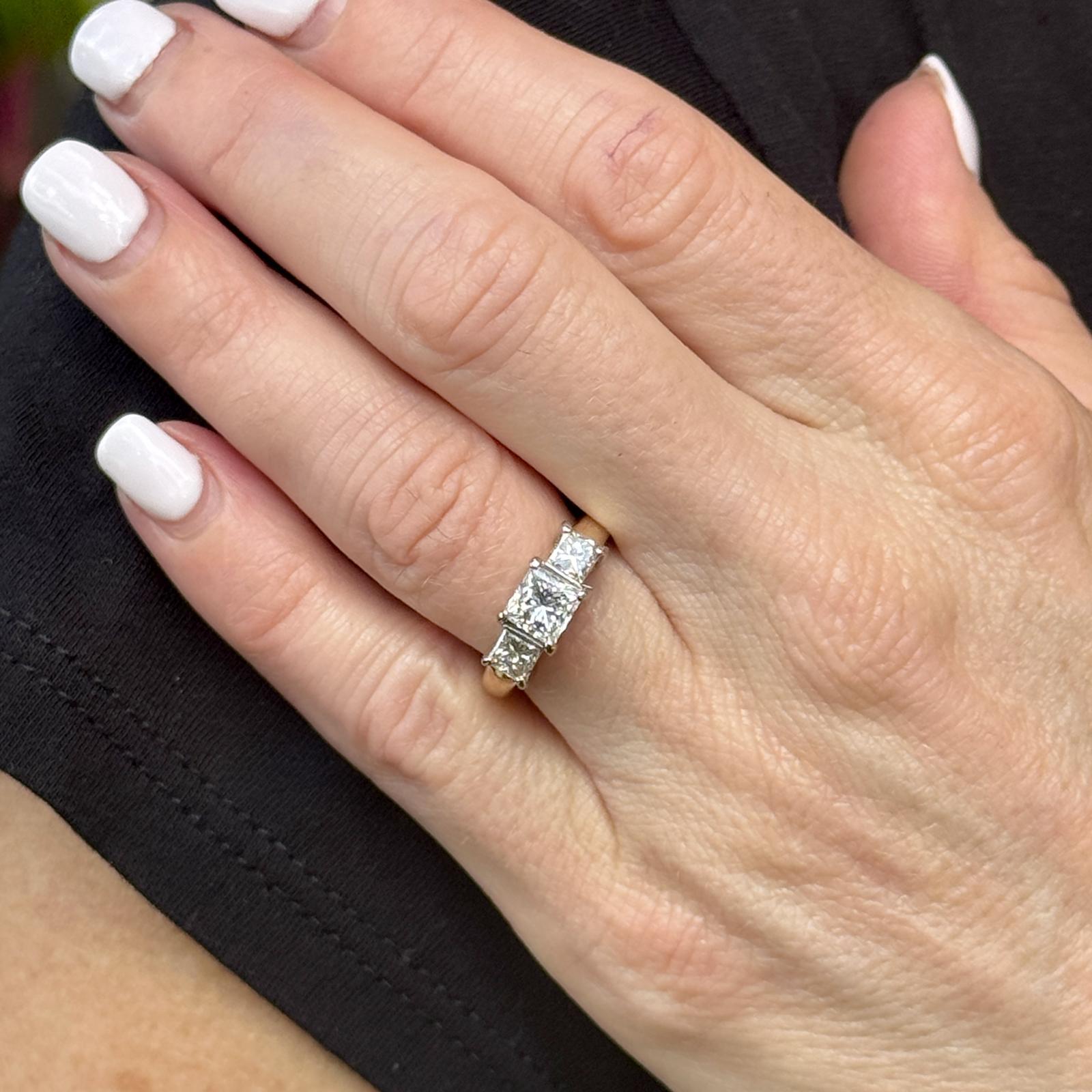 Dieser elegante, zweifarbige 14-karätige Goldring besticht durch sein zeitloses Design mit drei schillernden Diamanten im Prinzessinnenschliff. In der Mitte befindet sich ein atemberaubender 1,00-Karat-Diamant, der von GIA mit E in der Farbe und VS2