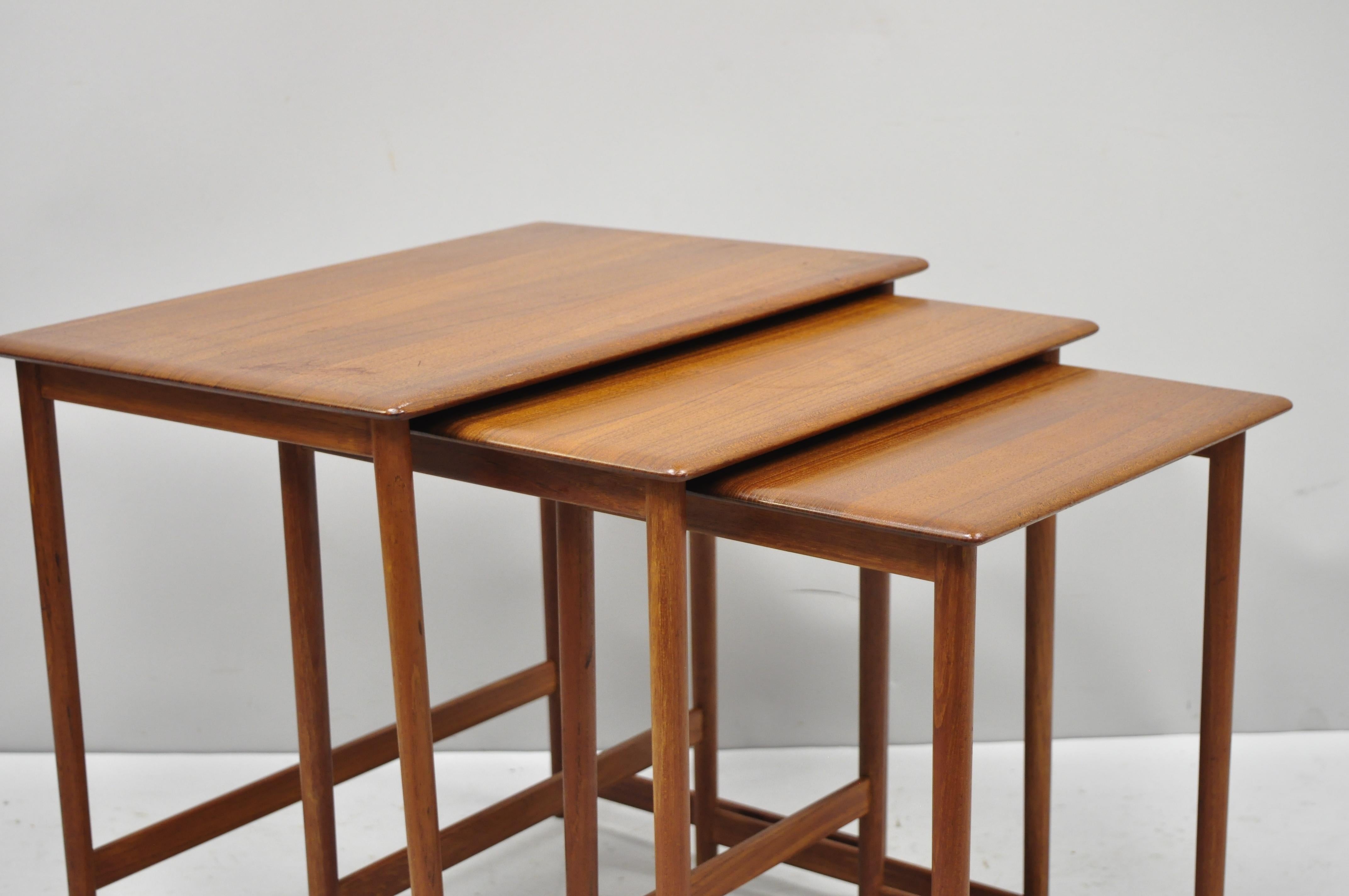 Three Rasmus Solberg Westnofa midcentury Danish modern Teak nesting side table. Listing features 3 graduating sizes, beautiful wood grain, original label, quality craftsmanship, sleek sculptural form, circa mid-20th century. Measurements: Large 19