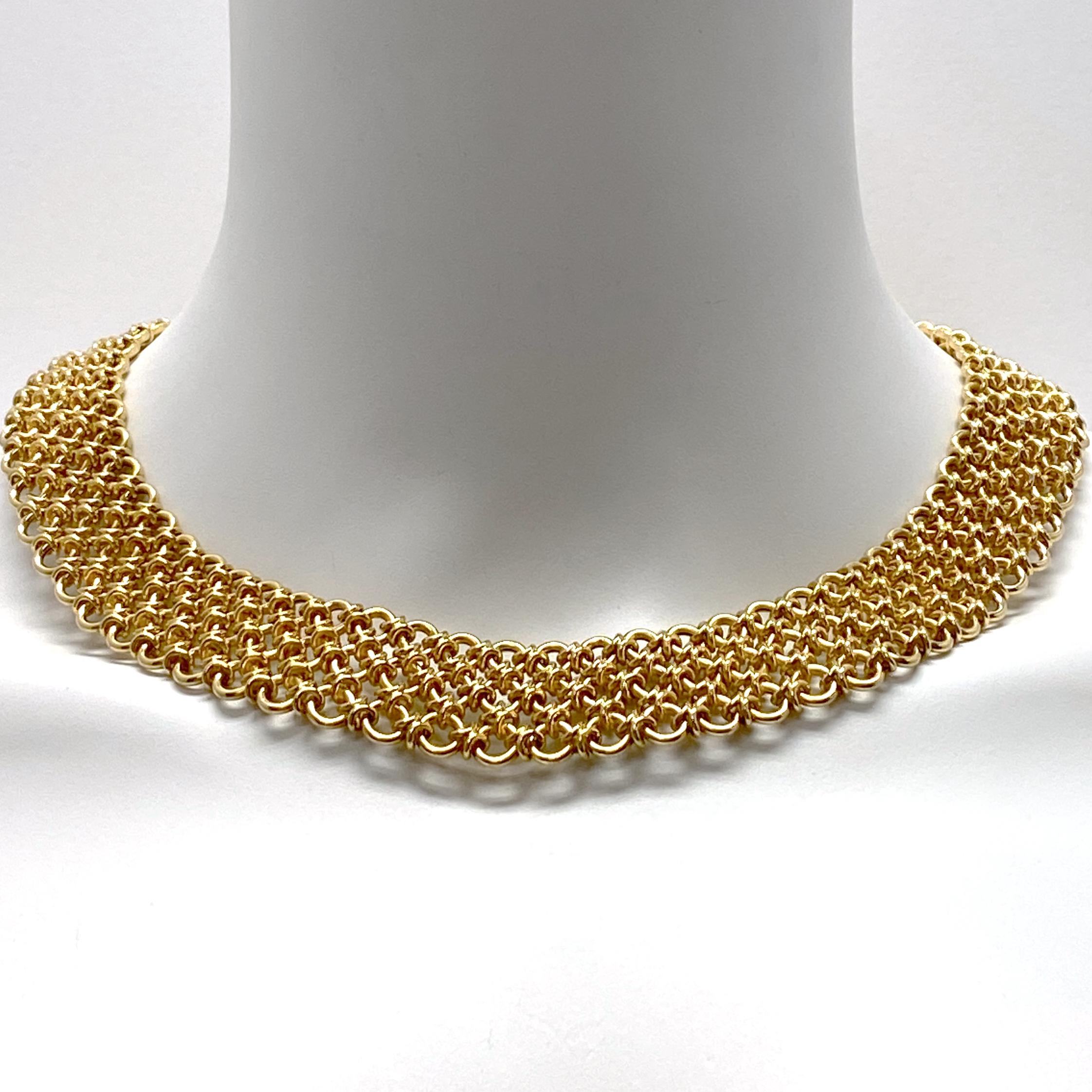 Endlessly versatile, sexy and substantial, this beautifully made gold collar is constructed of three rows of round rings, subtly graduated (smaller on top) to create the contour necessary to lie flat against the skin. Each ring is joined to its