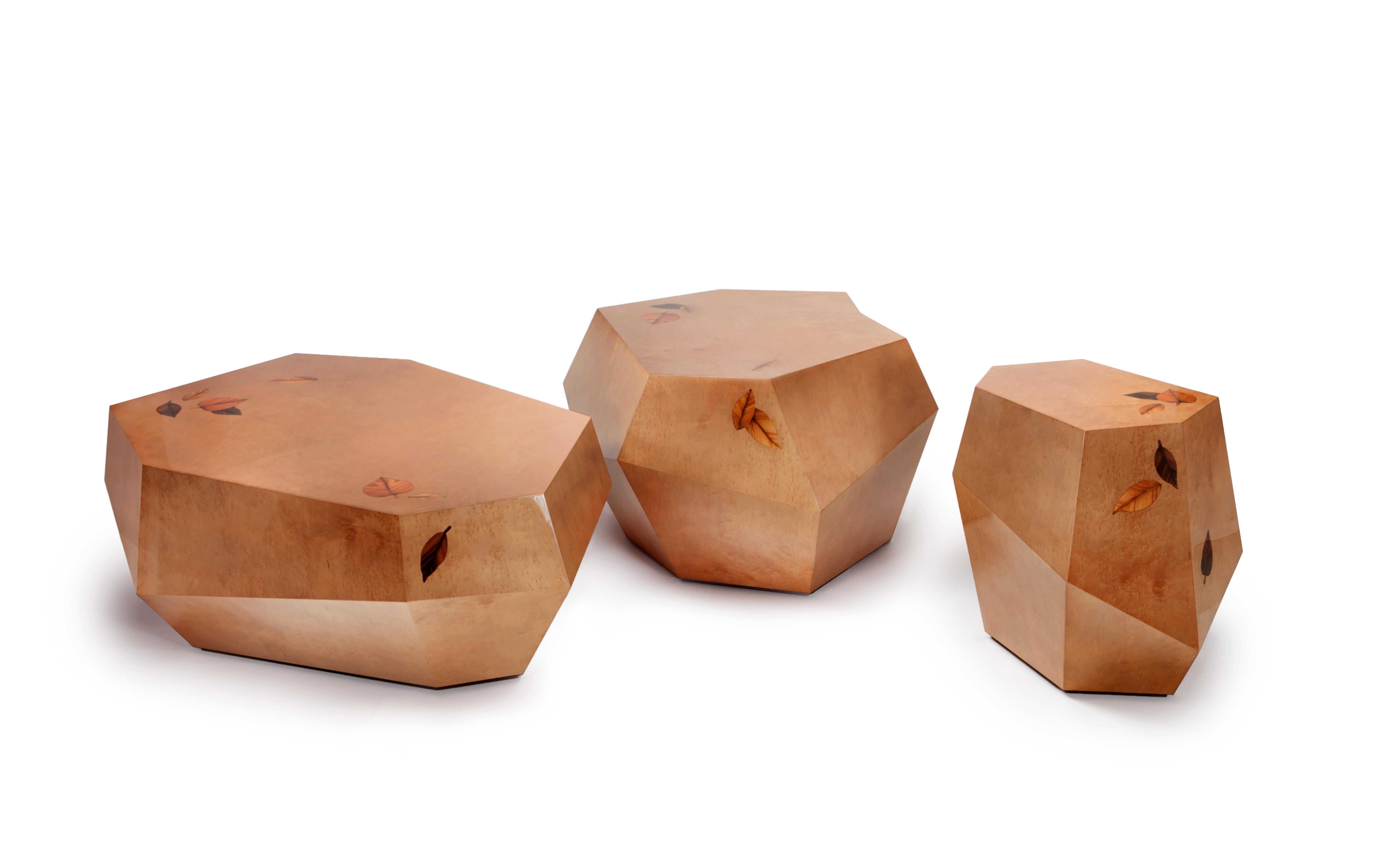 Die unregelmäßigen Formen der robusten Volumen der drei Rocks-Tische sind mit rauchbraunem Vogelaugenholzfurnier in Hochglanzlackierung ausgeführt. 
Die kleinen gepunkteten Knötchen dieses Furniers ähneln der Textur eines echten Felsens und der