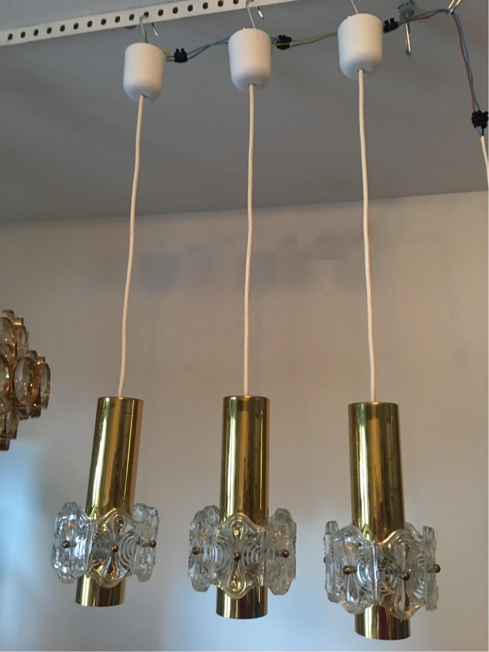 Three round ceiling lamps made of brass and glass from 1970s, Germany. The height indicated is the maximum height. It can be shortened to meet particular taste or need. Each fixture requires one European E 14 candelabra bulb, each bulb up to 40