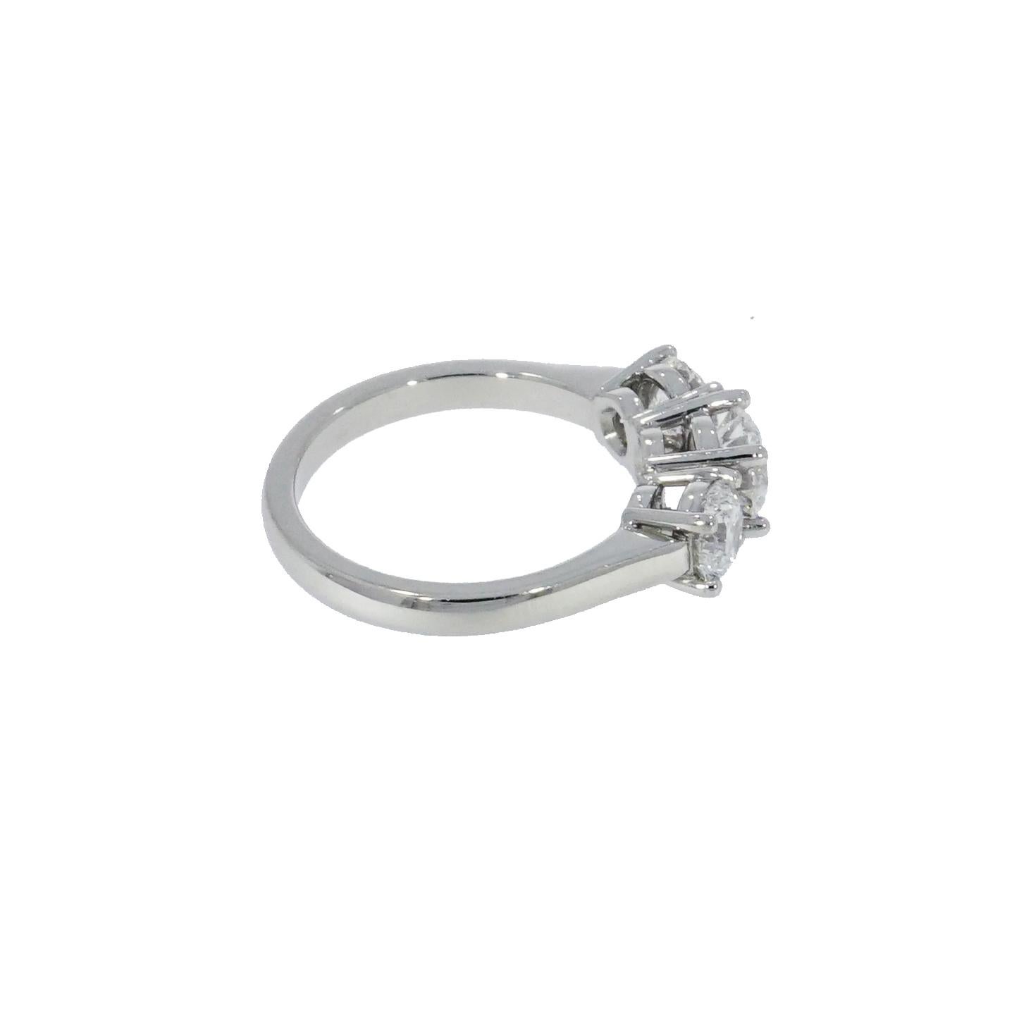 This three stone engagement ring features a 0.70 carat round brilliant cut center, E color, VVS2 clarity and is flanked by a 0.50 carat round diamond on each side, both in the same color and clarity as the center diamond. 
The Diamonds are set on a