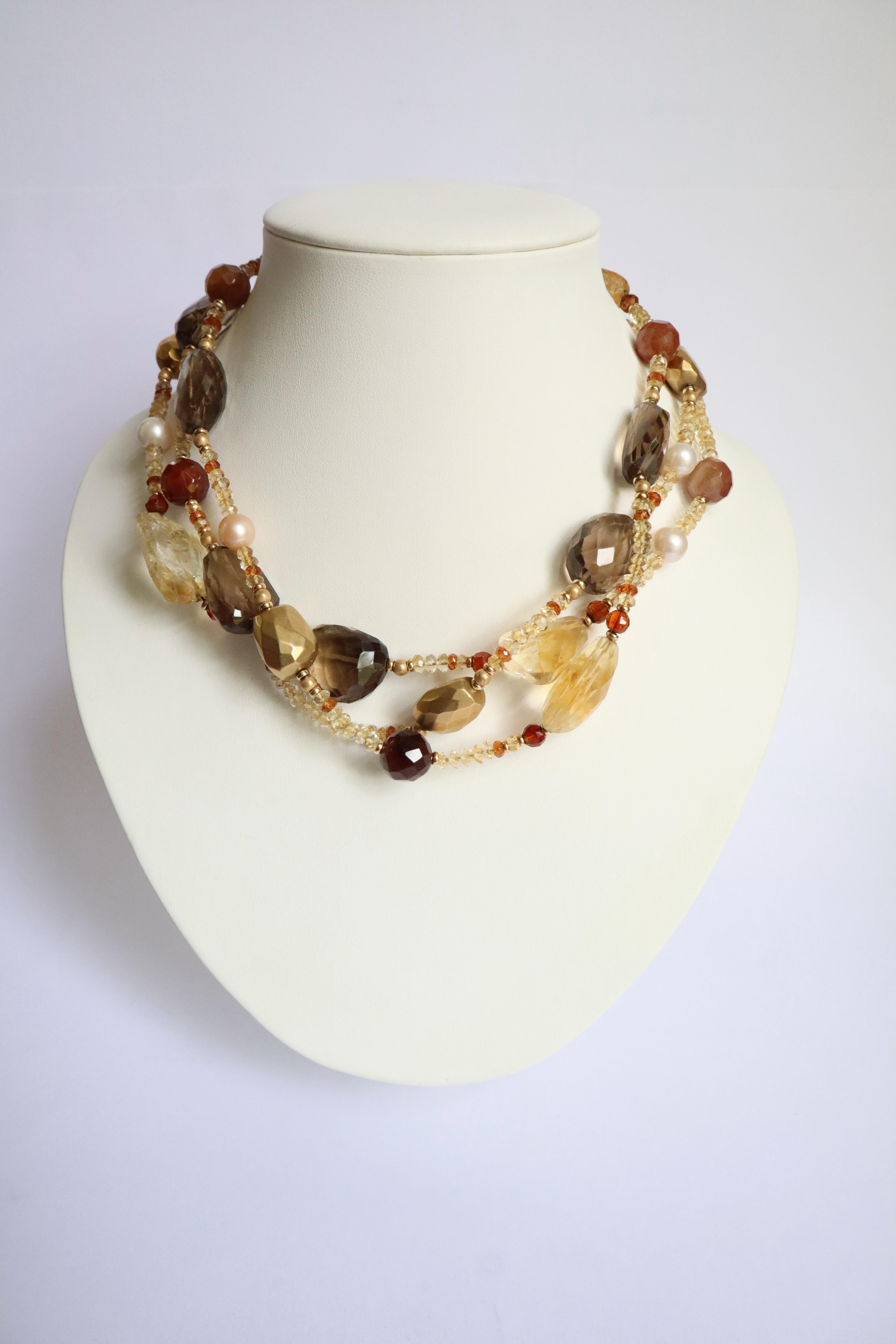 3 row necklace each composed of large faceted smoky quartz and large faceted citrines alternating with large faceted gold balls, pearls, small brushed gold balls, rose quartz, gold ferrule, citrine pearls and quartz. 
18 carats brushed yellow gold