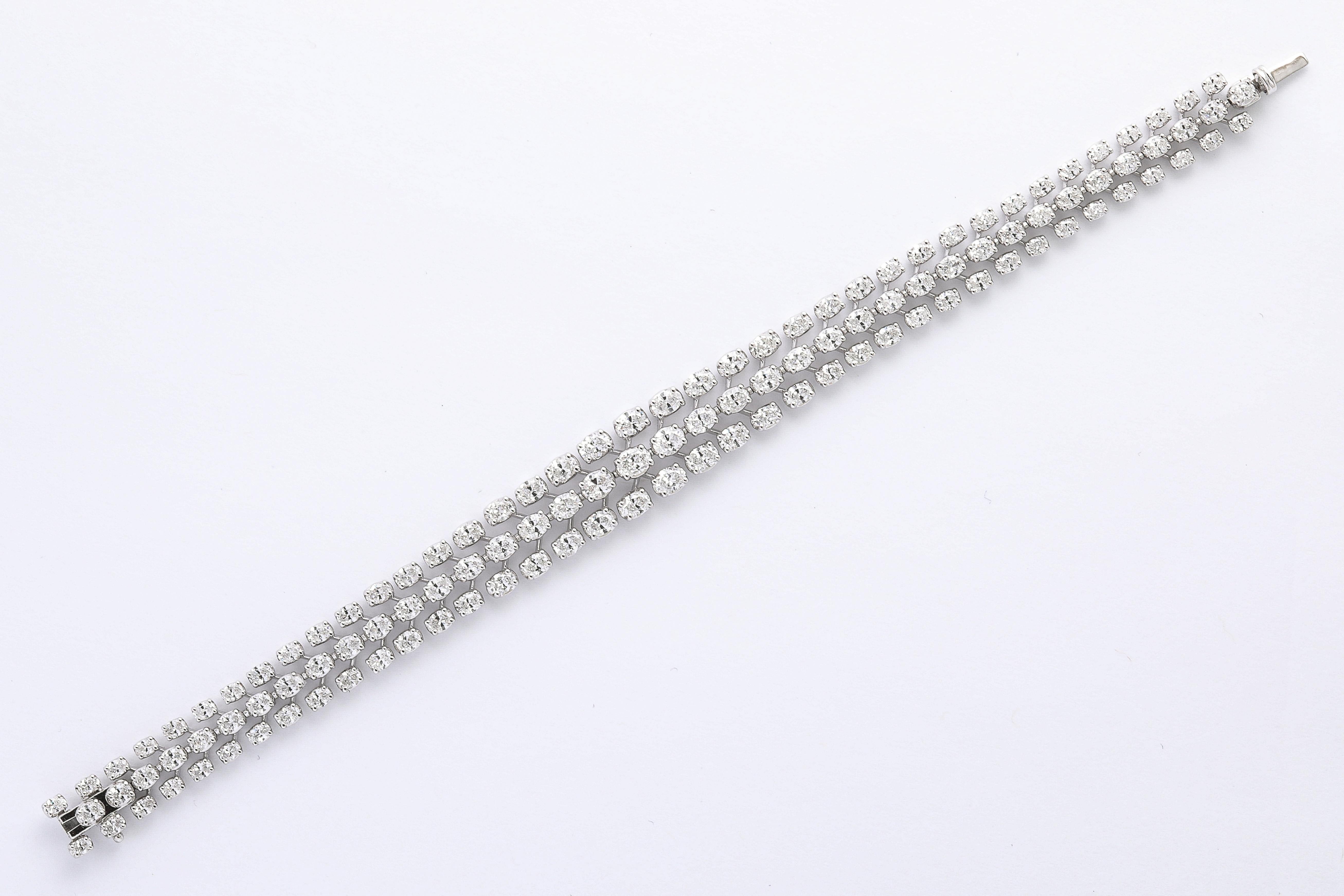 
Un superbe bracelet à trois rangs, facile à porter. 

11 carats de diamants blancs de taille ovale sertis dans de l'or blanc 18k. 

7 pouces de longueur - le bracelet est large d'un demi-pouce au centre.  