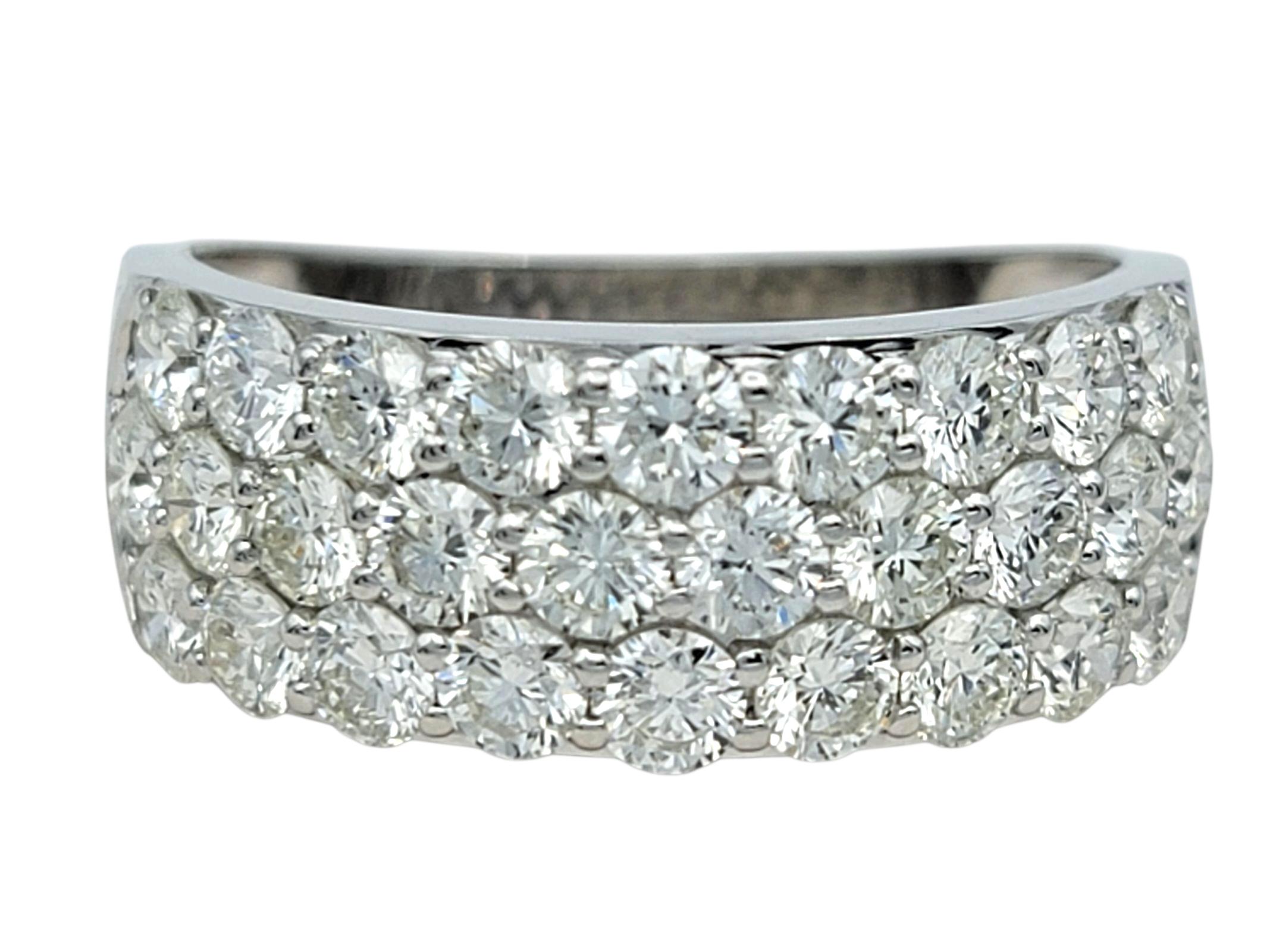 Dieser Diamantring besticht durch sein kühnes Design. Das breite Band aus poliertem 14-karätigem Weißgold ist mit einer Reihe von runden Diamanten im Brillantschliff besetzt, von denen jeder einzelne ein außergewöhnliches Funkeln und eine