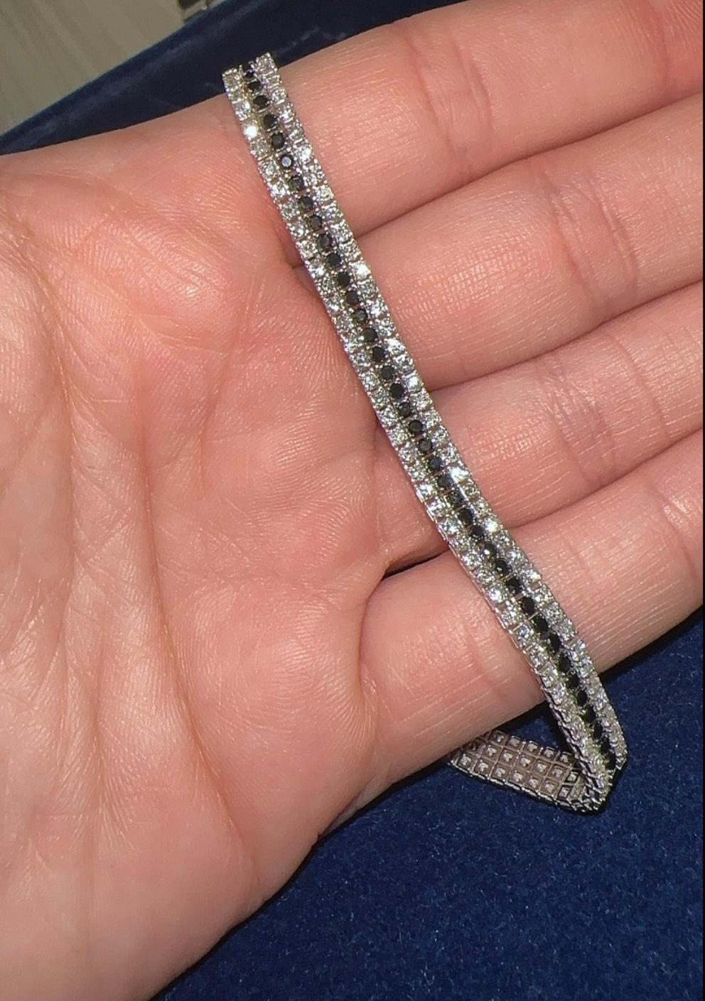 Bracciali tennis a tre file con diamanti bianchi e neri. Questo squisito bracciale tennis a tre file presenta una splendida composizione di diamanti naturali bianchi e neri, elegantemente incastonati in oro bianco 18 carati. Il contrasto tra i