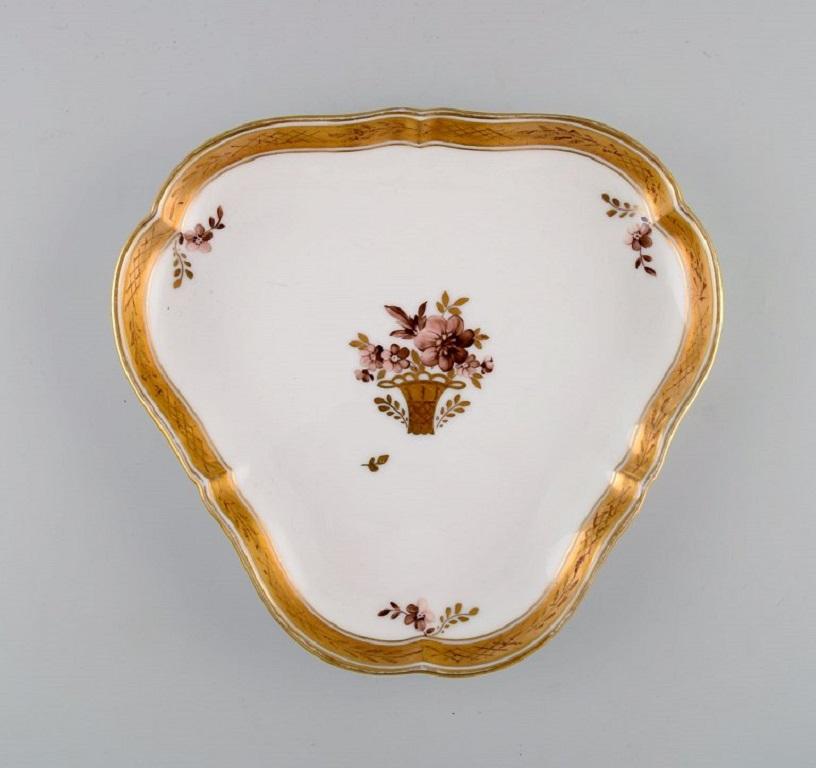 Three Royal Copenhagen golden basket dishes in porcelain with flowers and gold decoration. Early 20th century.
Round dish measures: 27.5 x 25 cm.
In excellent condition.
Stamped.
1st factory quality.