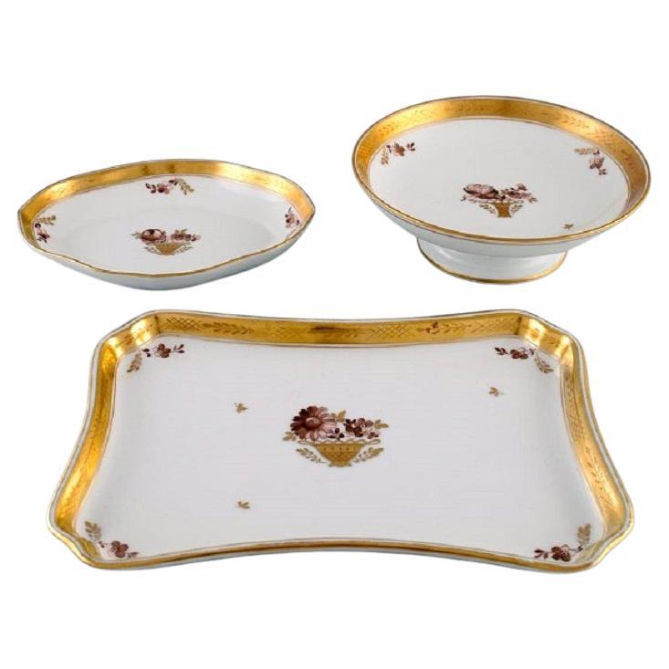 Tre piatti Royal Copenhagen con cesto d'oro in porcellana e fiori