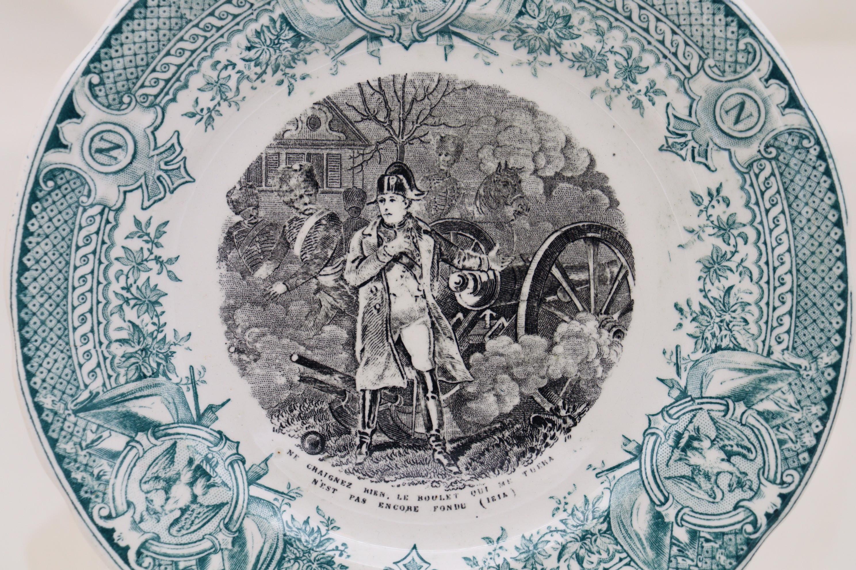 These three Sarreguemines side plates are decorated with different transfer printed scenes of Napoleon's battles, in black, to the centre, within an intricate aqua coloured printed border. Beneath each scene is the individual caption in French. They
