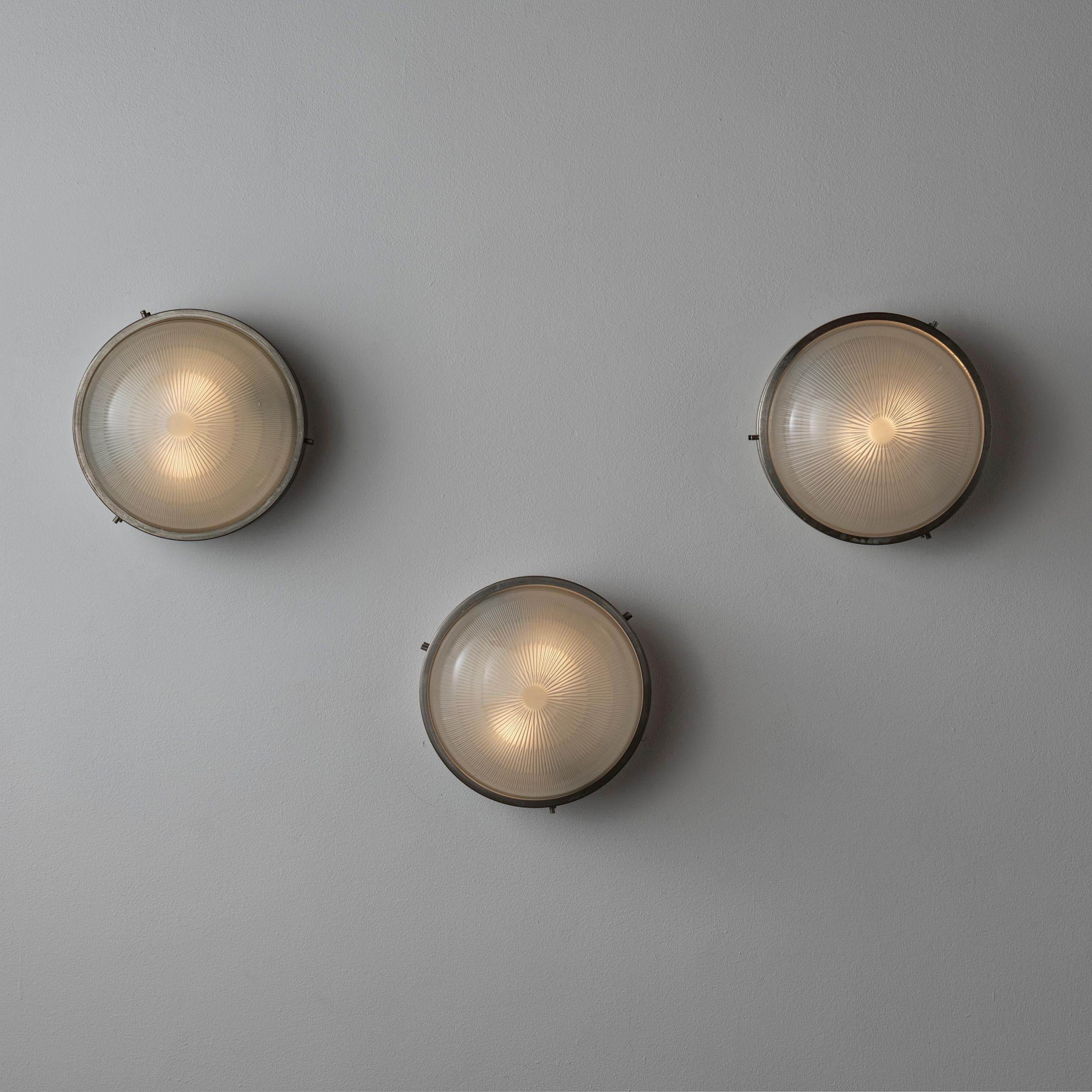 Sconces by Sergio Mazza. Designed and manufactured in Italy, circa 1960s. Patinated nickel plated brass, holophane glass. Custom backplates. Rewired for U.S. standards. We recommend three e27 40w maximum bulbs per sconce. Bulbs provided as a one