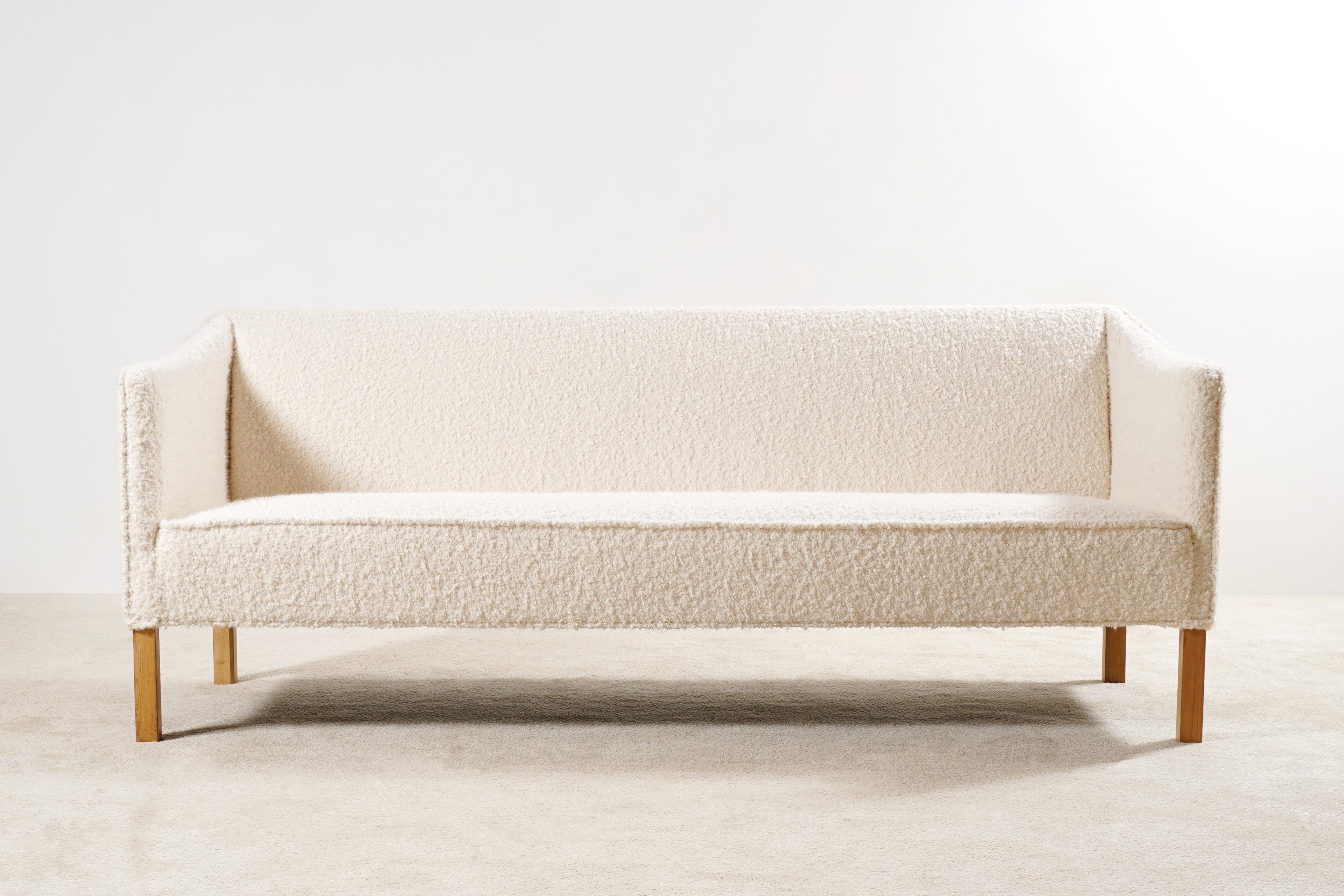 This three-seat sofa is an original piece from the 1950s, manufactured in Denmark.
Oak wood natural color waxed feet.

This sofa has been fully restored and newly upholstered in the traditional way by the best French craftsmen, we used a high