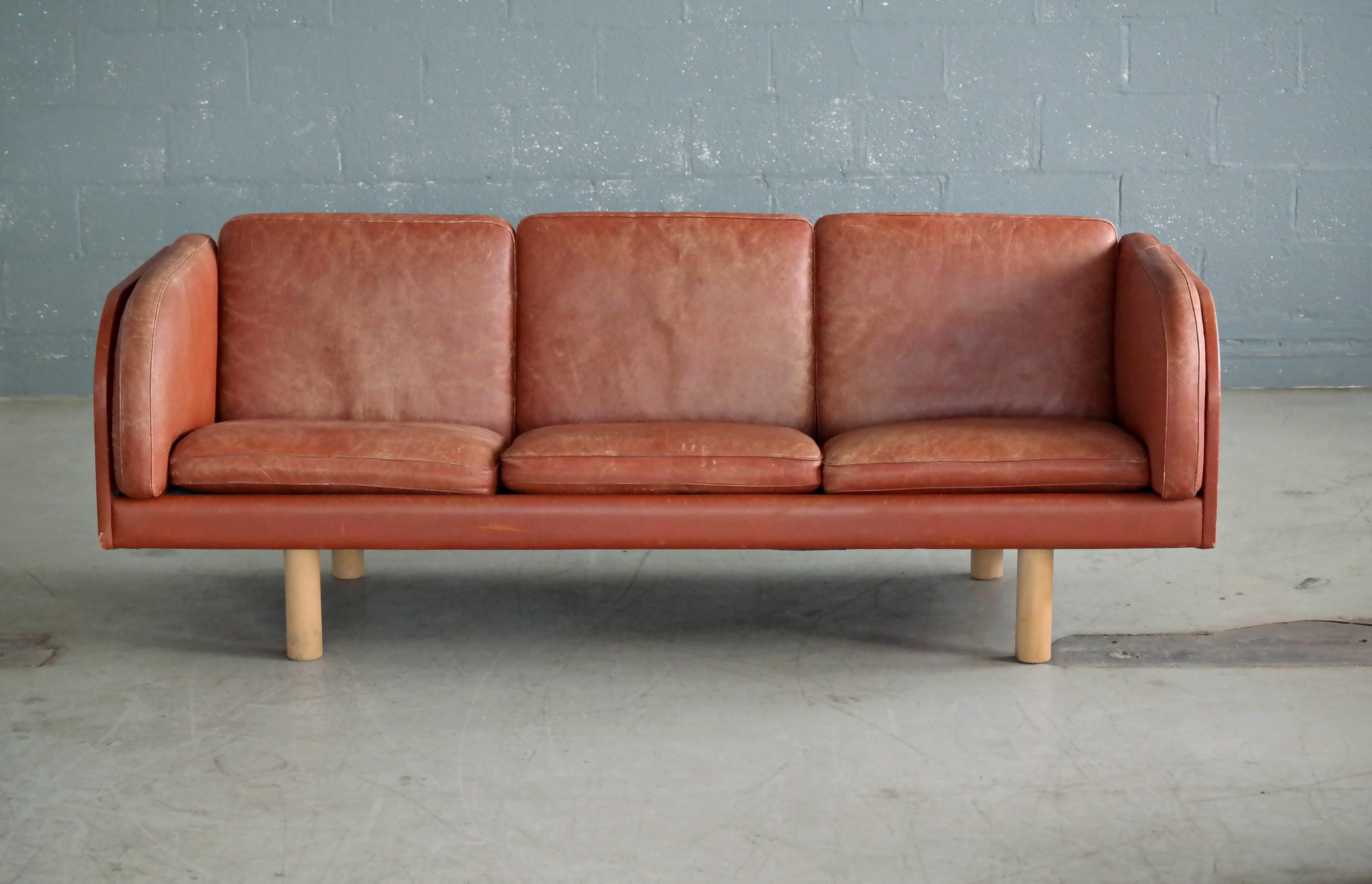 Great three-seat sofa, model EJ-20-3 designed by Jørgen Gammelgaard for Erik Jørgensen furniture factory in the early 1970s. The sofa is upholstered in cognac colored patinated natural leather. The sofa shows and patina and noble wear throughout but
