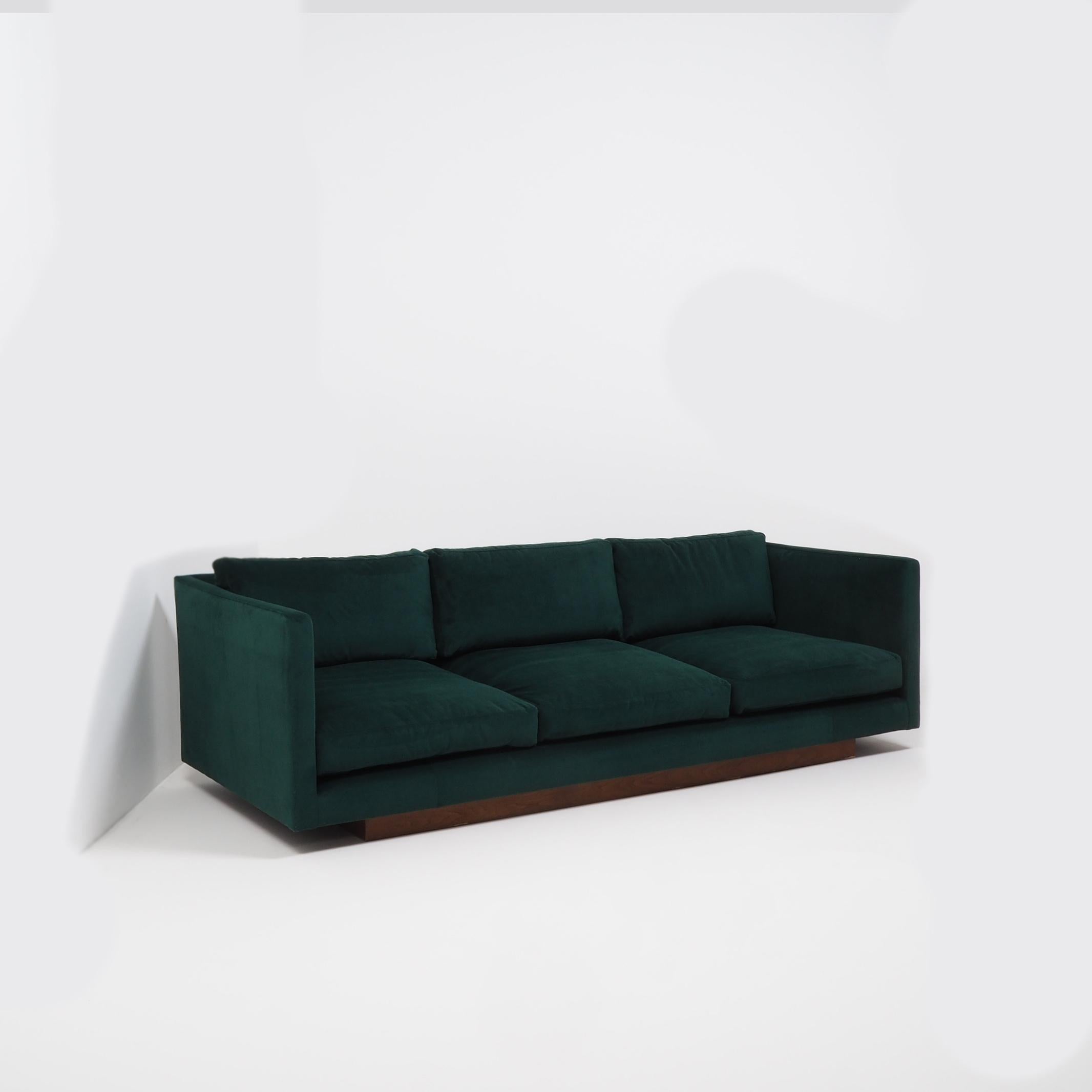A Minimalist 1960s design, this tuxedo three-seat sofa has been newly and fully reupholstered in sumptuous forest green velvet.
 
Designed by Milo Baughman for Thayer Coggin, the sofa features a slim, angular Silhouette with a set back wooden