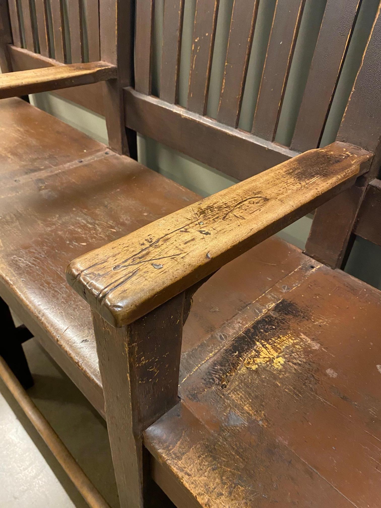 Three seat solid maple shoe shine bench.  Heavy weight and solid construction, the bench is styled in the arts and crafts period aesthetic.  Each seat has arms and a foot rest, while the slatted back runs the length.  Remnants of paint and stain