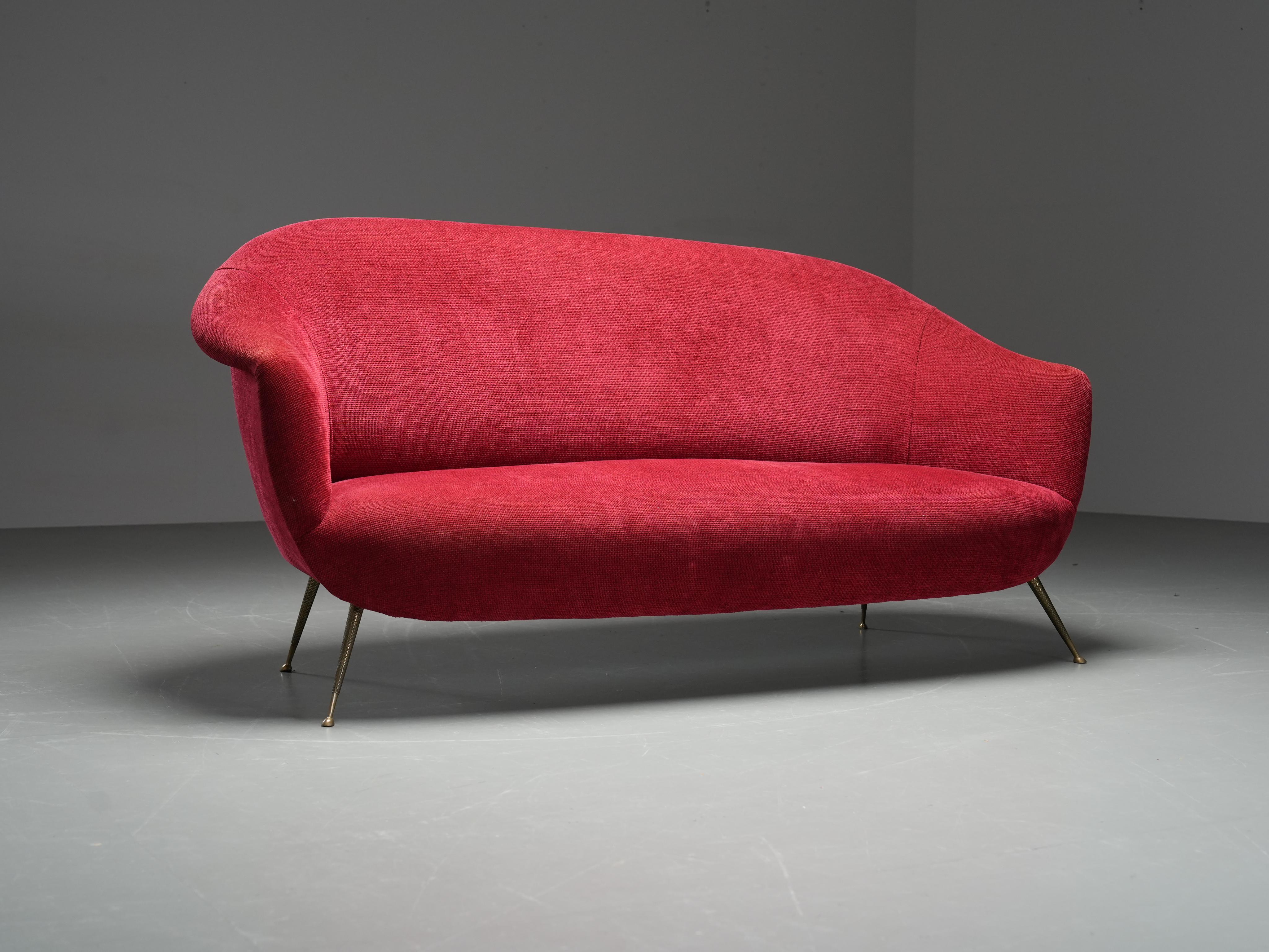 Italian sofa from the 1960s with a refined organic silhouette and deep red upholstery. The gently curved backrest and armrests give the piece a soft, elegant presence, while the tapered brass legs create a light and airy profile.

The legs feature a