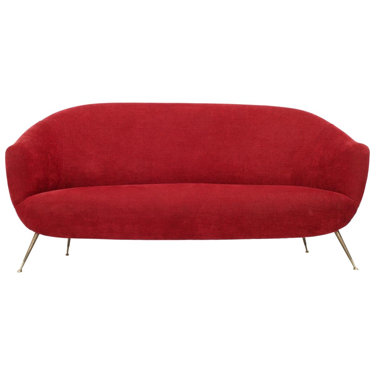 Bequemes und einladendes Dreisitzsofa mit Messingfüßen. Ein elegantes Sofa, das ein wenig an einen Mund mit roten Lippen erinnert. Die Beine, die ein wenig nach außen stehen, sind ziemlich minimal, aber weil sie aus Messing hergestellt wurden, sind