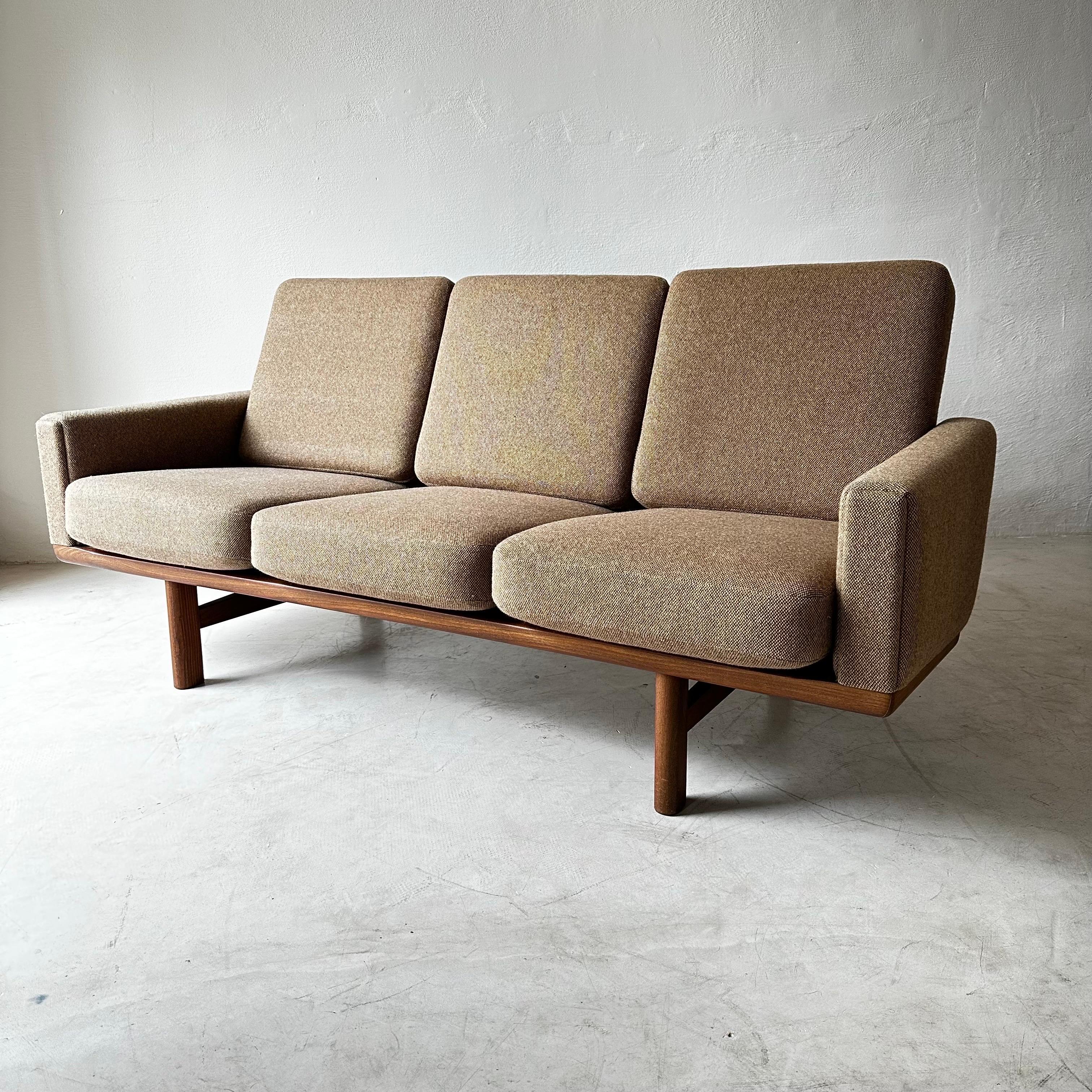 Hans Wegner designed this comfortable three-seat sofa, model GE-236, for GETAMA in the mid-1950s. It features an angled solid teak frame whose slats create a handsome lattice in back. Original upholstery in gently used condition, ready to be