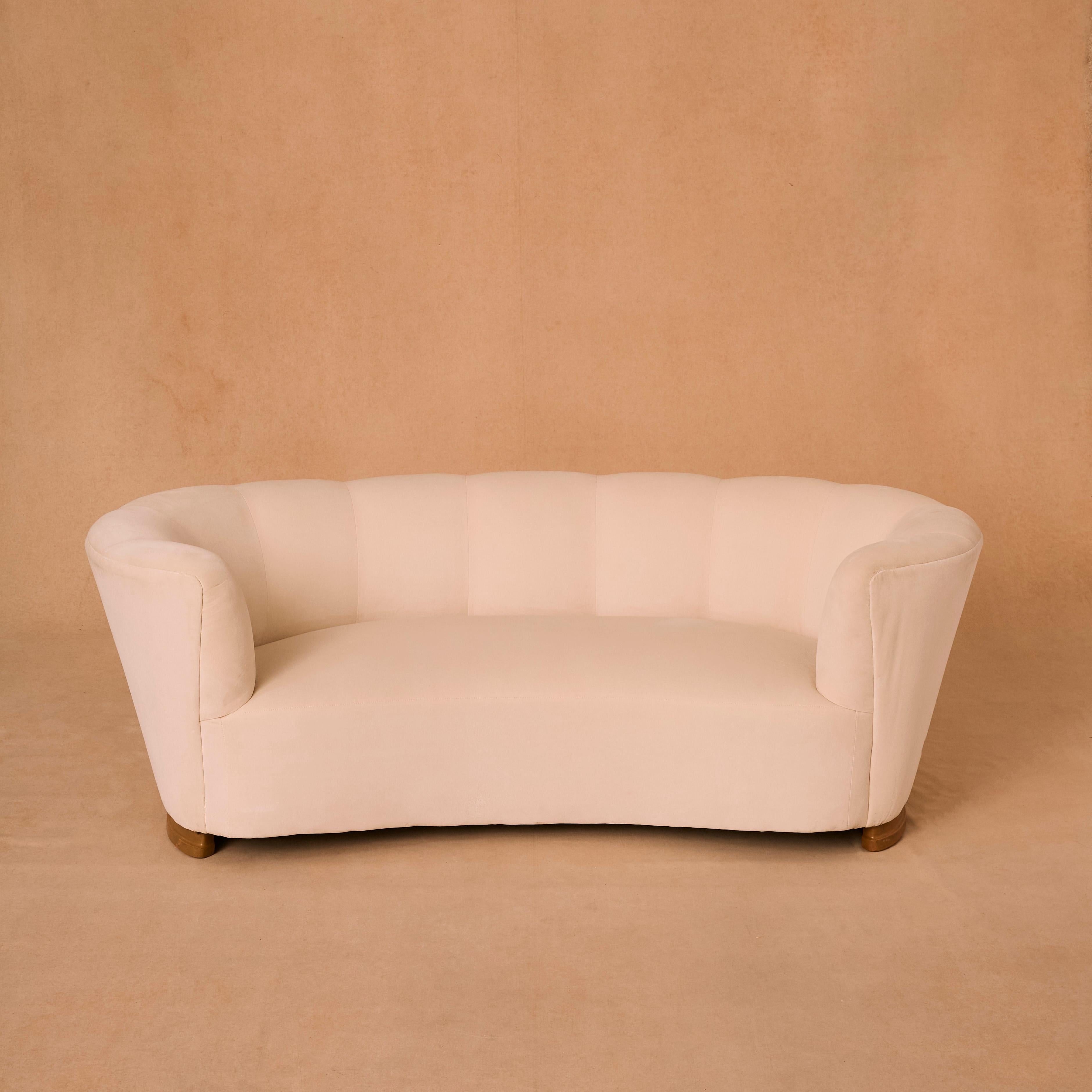 Three seater banana sofa upholstered in cream cotton velvet Danish design.