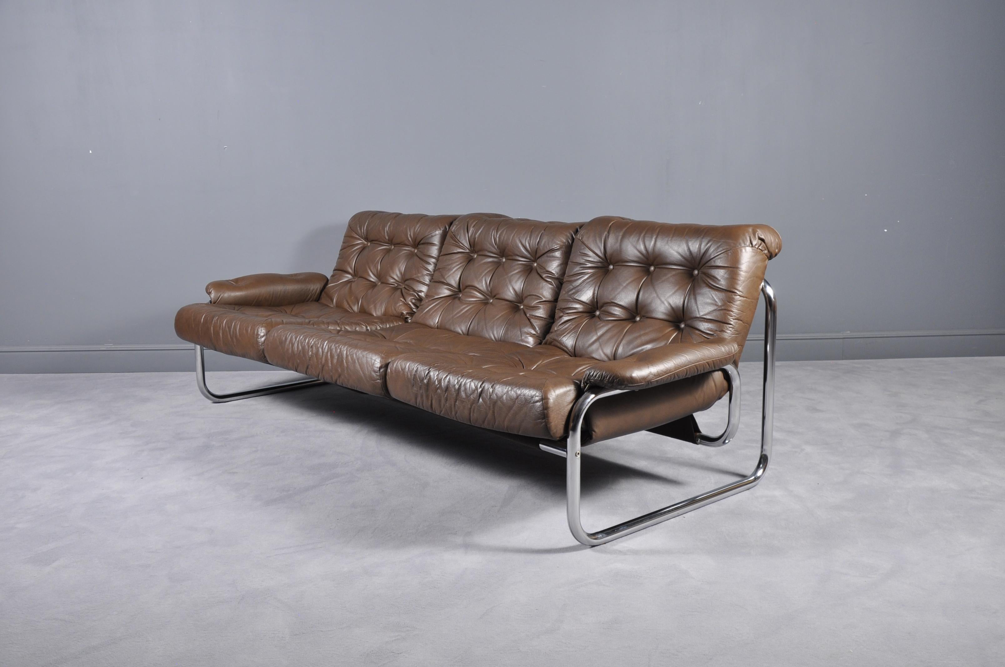 Swedish, 1970s tubular metal framed lounge sofa with original brown tufted cushion and armrests. Produced by Ikea, model Troligen, designed by Johan Bertil Häggström.
 