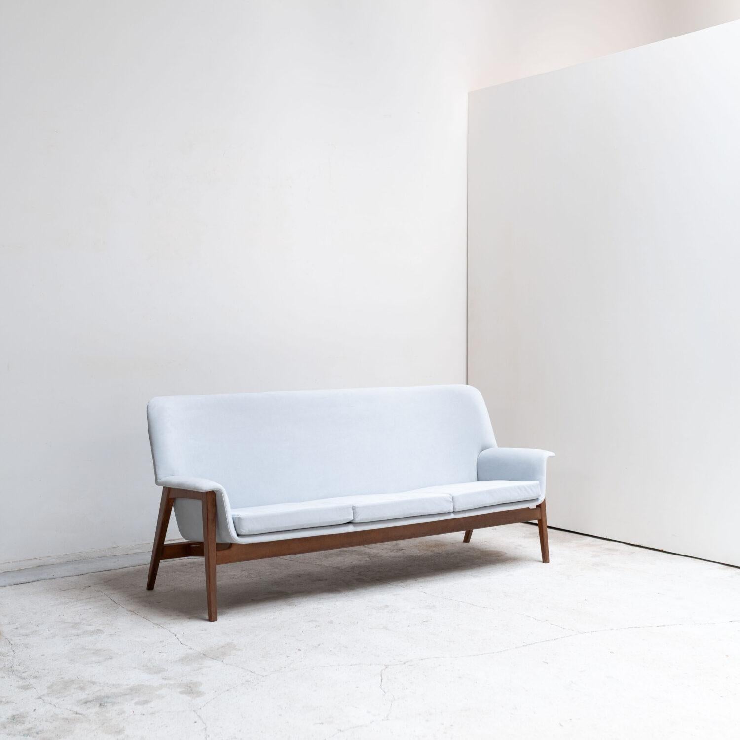 Three seater sofa designed by Isamu Kenmochi, featuring soft blue upholstery and a refined wood frame.