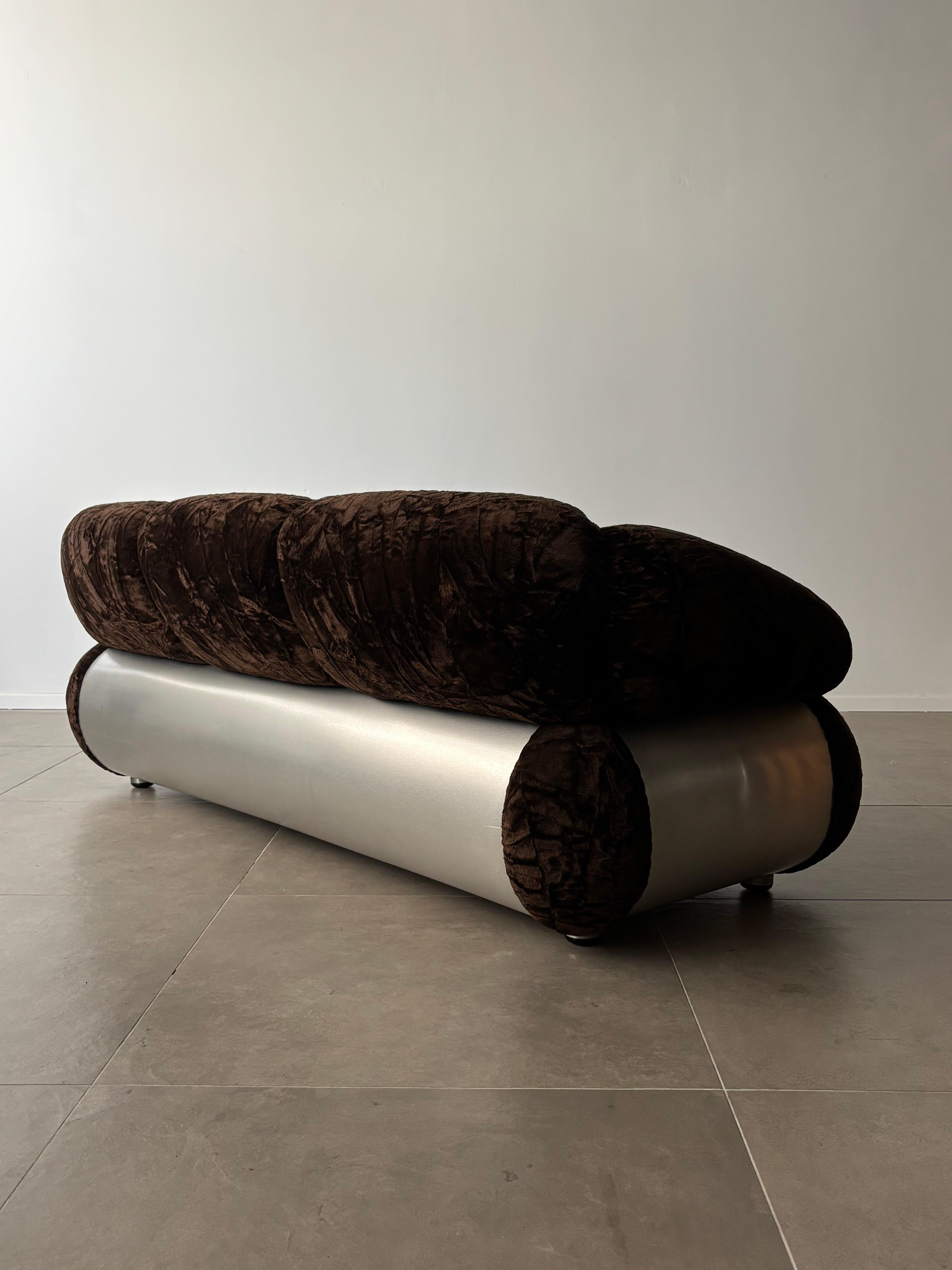 Dieses Dreisitzer-Sofa wurde in den 1970er Jahren von Adriano Piazzesi in Italien entworfen und ist ein eindrucksvolles Beispiel für die kühne und doch raffinierte Design-Sensibilität dieser Zeit. Mit seinem originalen braunen Samtbezug strahlt das