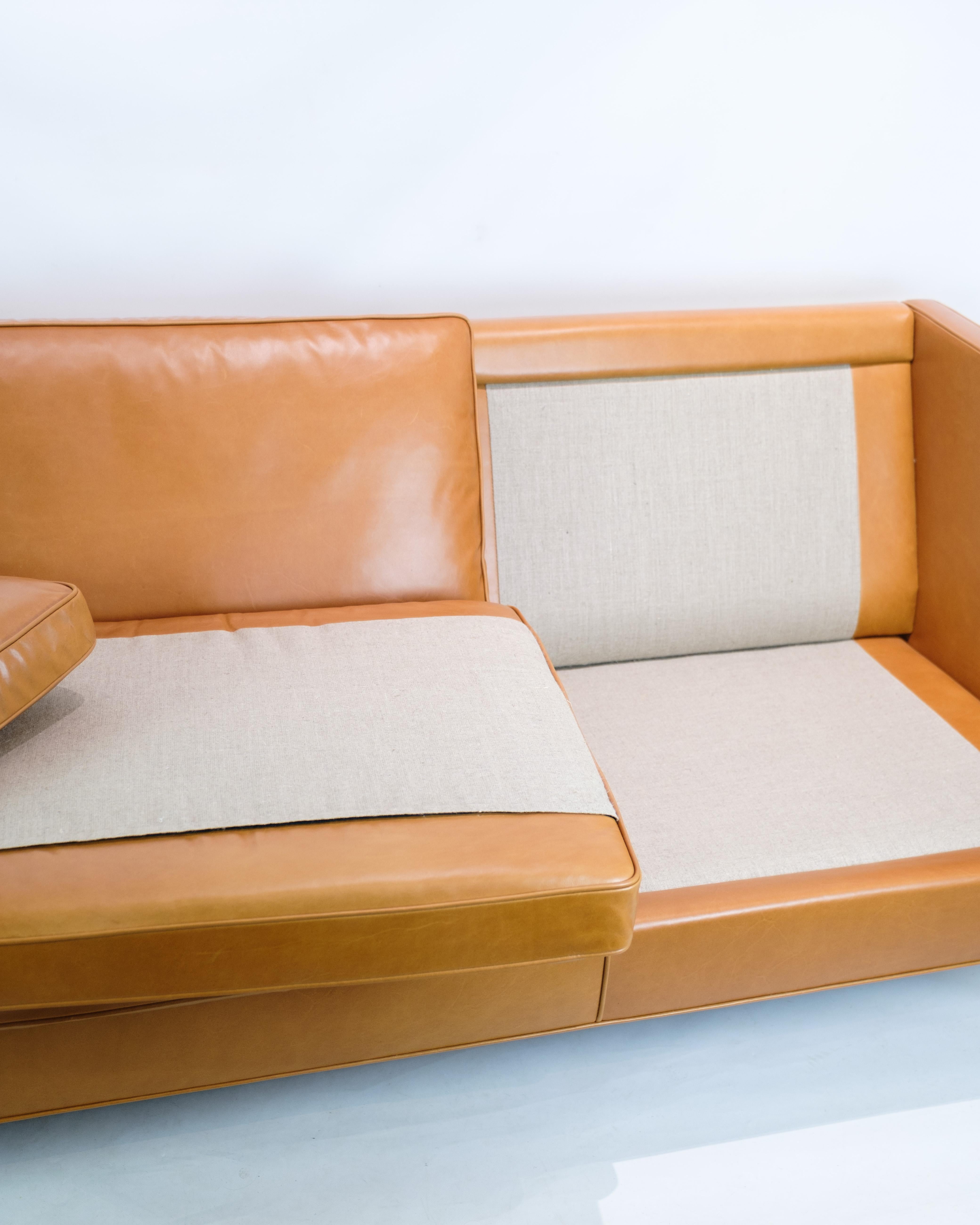 Forkæl din stue med luksus og tidløs elegance med denne 3-personers sofa, model 2333, designet af den anerkendte Børge Mogensen og produceret af Fredericia Furniture omkring 1960'erne. Betrukket med blødt cognacfarvet læder, udstråler denne sofa en