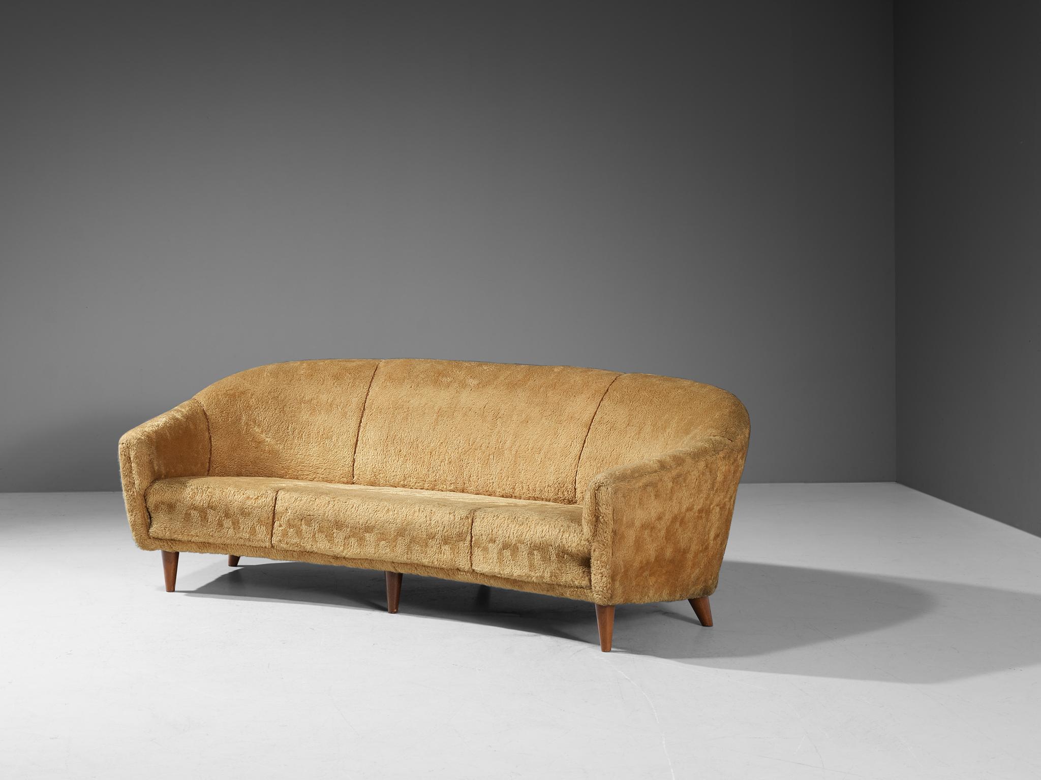Three-seater sofa, teddy upholstery and beech, Europe, 1950s

This voluptuous sofa is executed with wooden legs and a yellow teddy upholstery. The sofa has a high lined and slightly curved back, while the backrest is horizontal straight and flows