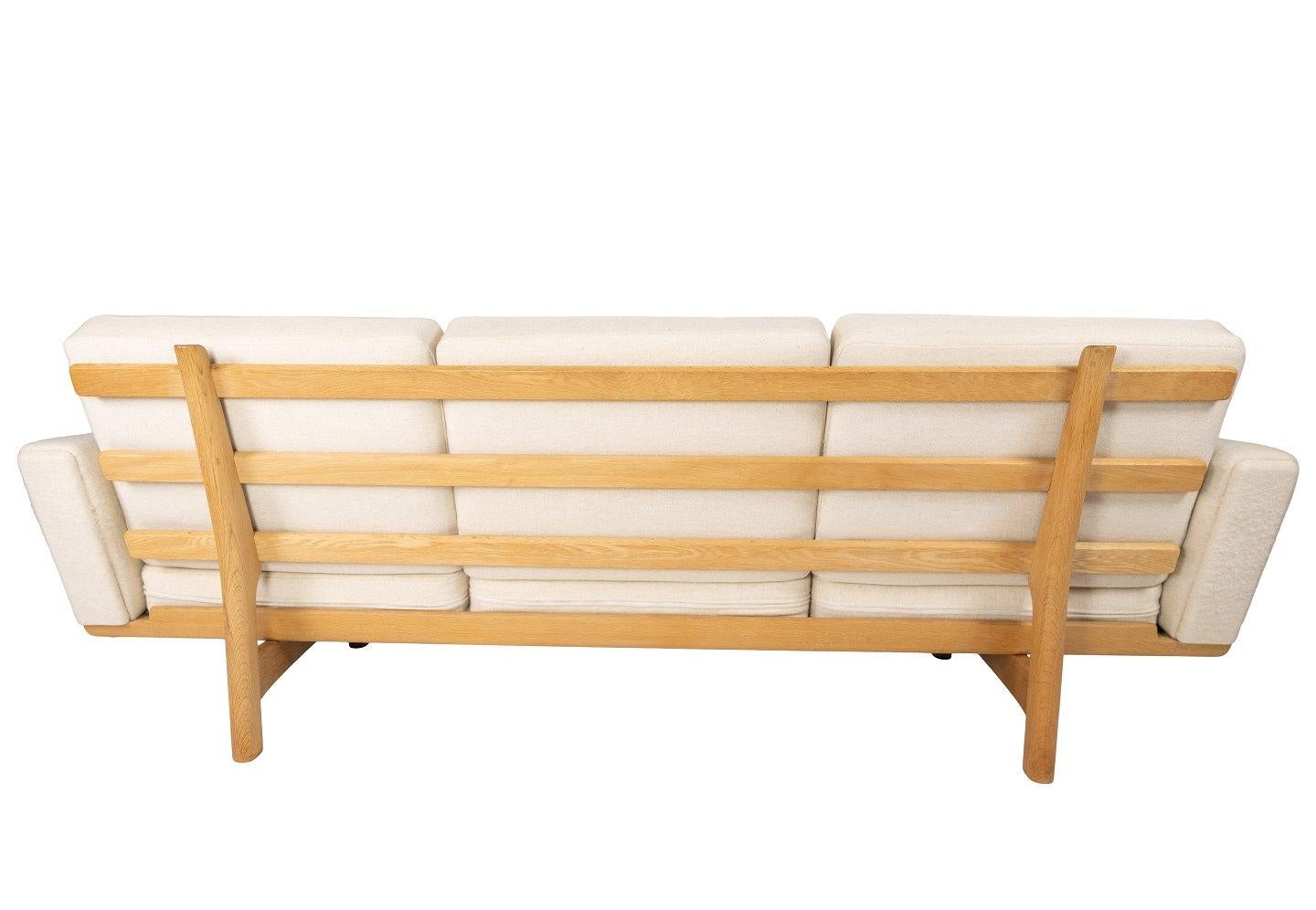 Three-seat sofa, model GE-236/3, designed by Hans J. Wegner and manufactured by GETAMA in the 1960s. The sofa is upholstered with light wool fabric and of oak.