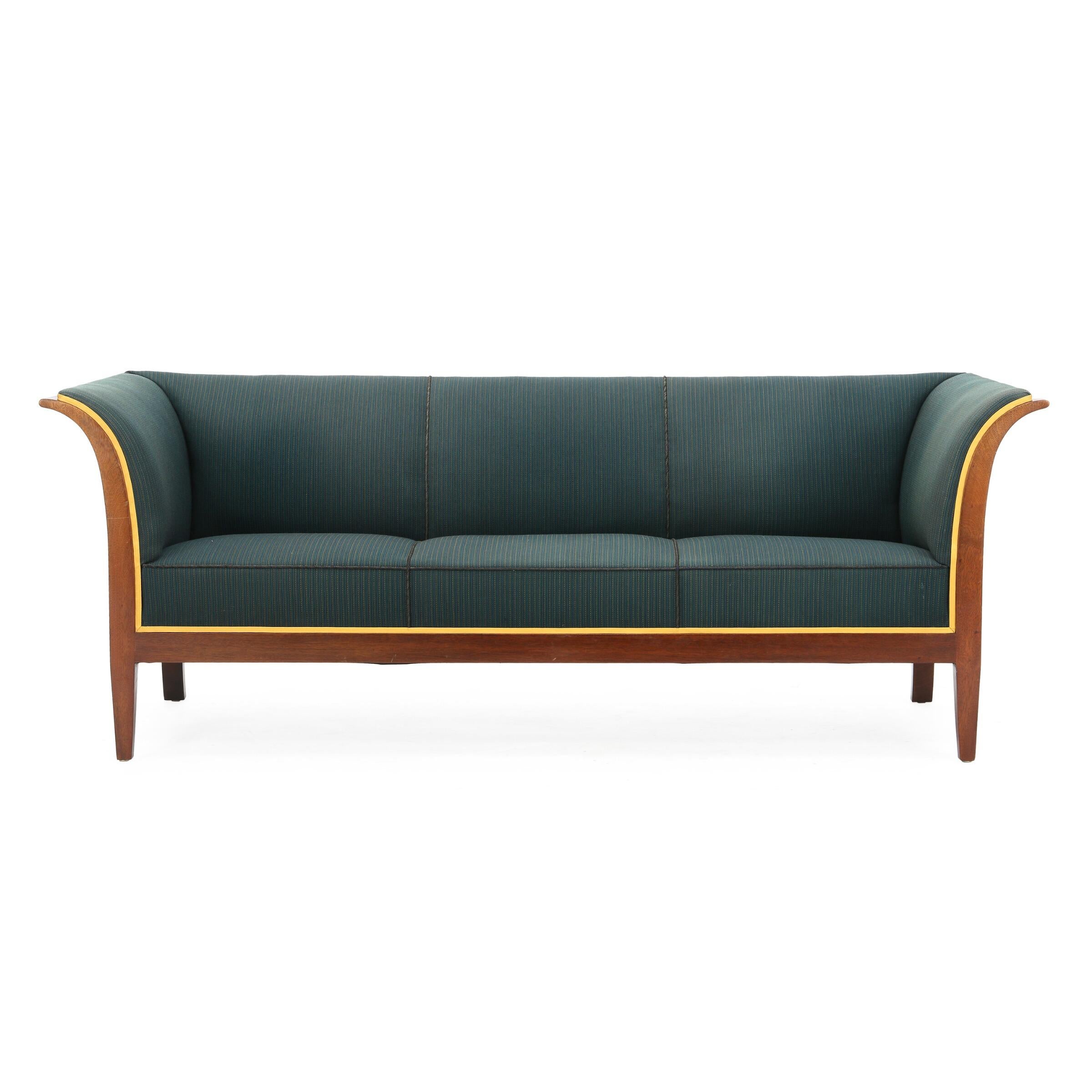 Neoclassical style freestanding three-seat sofa with mahogany frame. Danish modern, circa 1950s. Sides, seat and back upholstered with blue, yellow and green striped wool. Yellow edgings. Made by cabinetmaker Frits Henningsen.