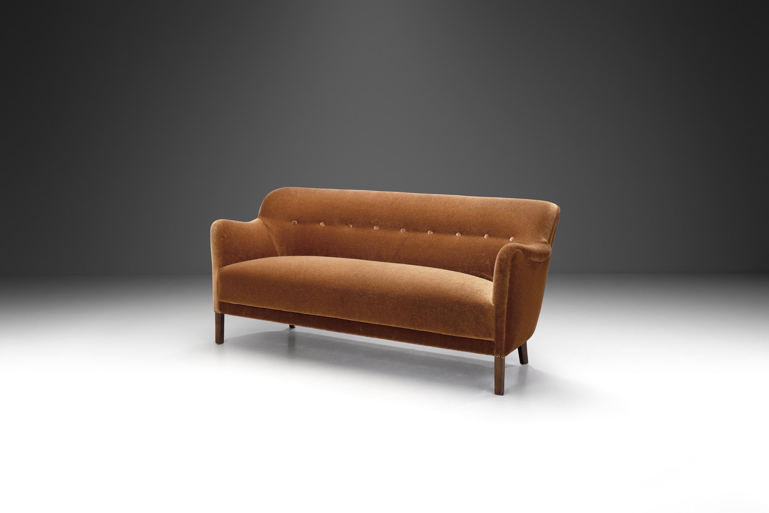 Dieses charmante Sofa wurde in der frühen Phase dessen entworfen, was wir heute als Mid-Century Modern bezeichnen. Es ist ein Beweis dafür, wie die traditionelle dänische Handwerkskunst in die Moderne integriert wurde.

Die geschwungene Rückenlehne