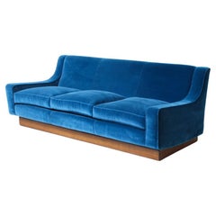 Vintage Three-seater sofa with wooden base and velvet upholstery.