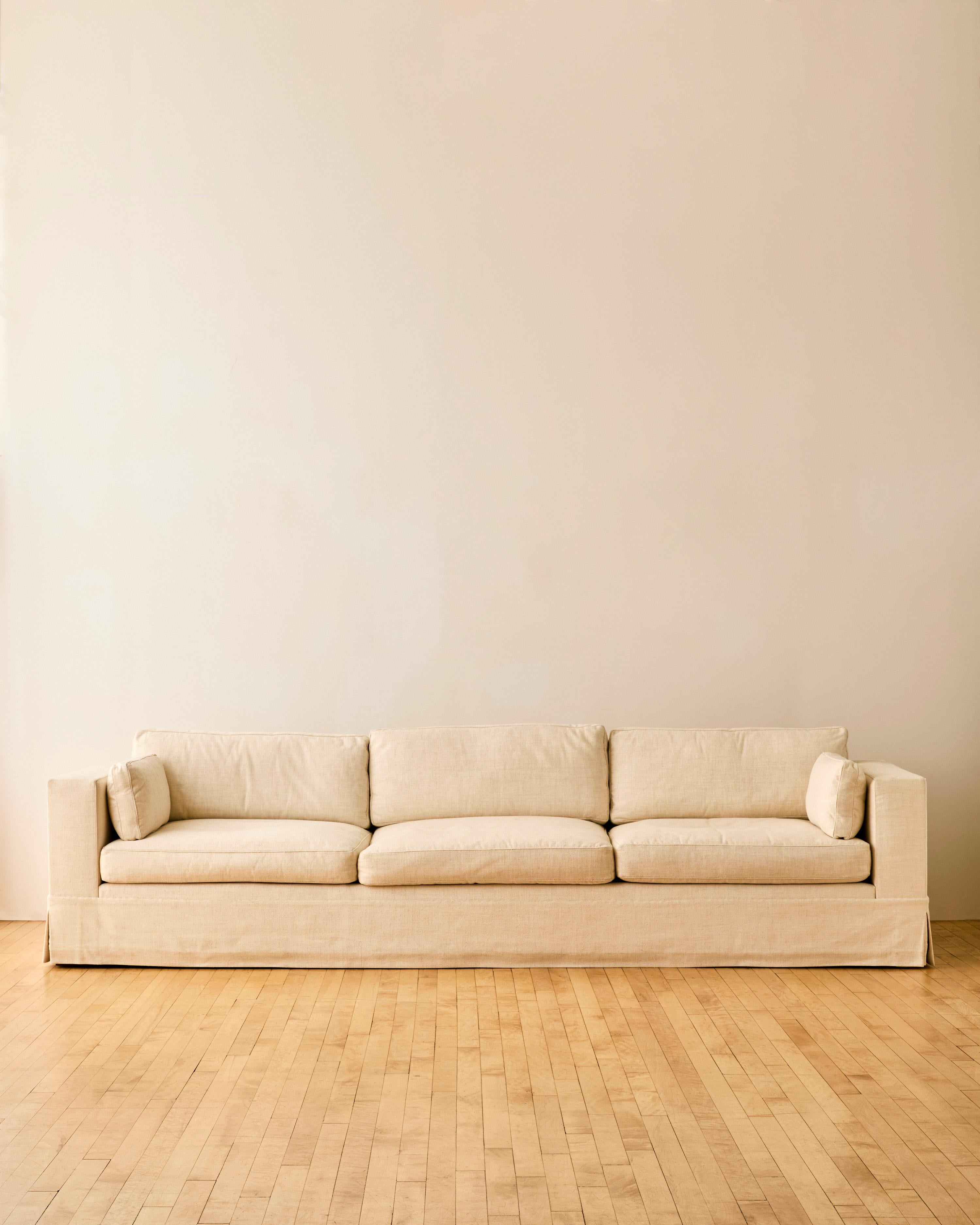 Three seater linen custom sofa with Jonas Fine Upholsters fabric label. 