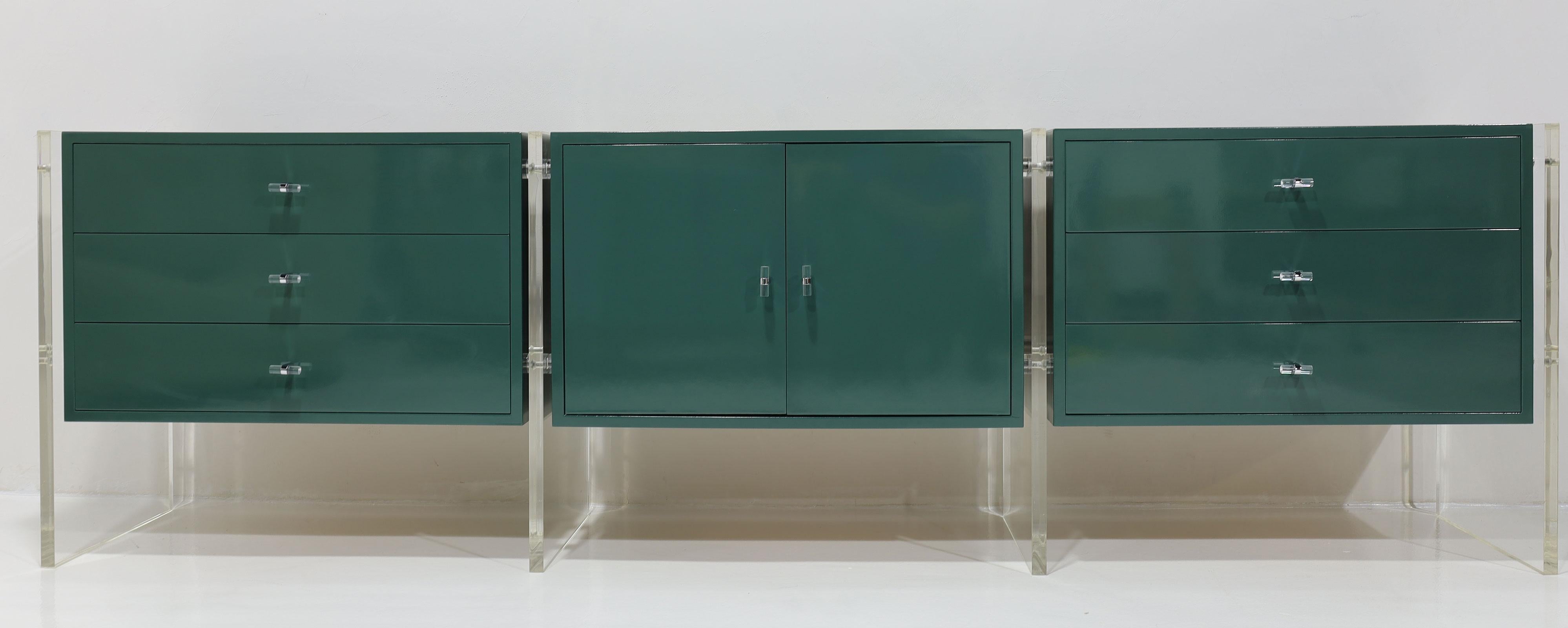 This is a great looking sideboard. It has three sections and is supported by thick Lucite legs. There are two sections with drawers and the middle section has a shelf. We have replaced the knobs with Lucite and chrome knobs and lacquered the case