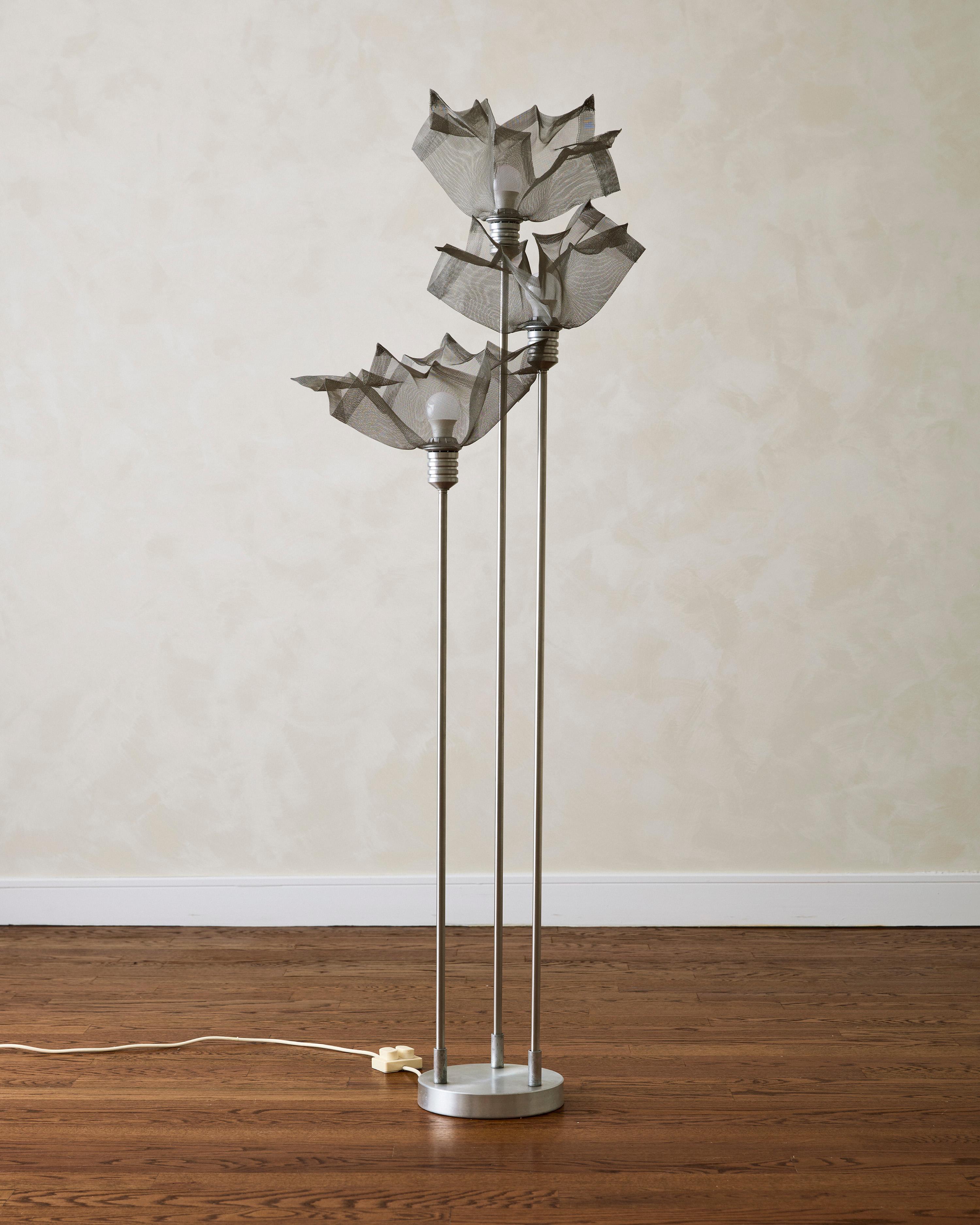 Lampadaire à trois abat-jours attribué à Giuseppe Raimondi. La structure en aluminium est complétée par trois abat-jour sculpturaux en maille métallique, pour créer une composition d'inspiration florale.