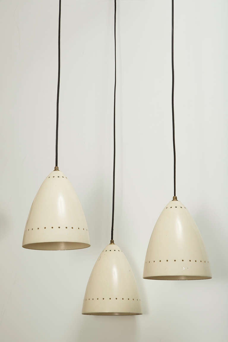 Three Shade Chandelier designed in Italy circa 1950s. Painted metal shades with perforation. Brass hardware and custom canopy. Wired for US junction boxes. Each shade takes one E27 60w maximum bulb