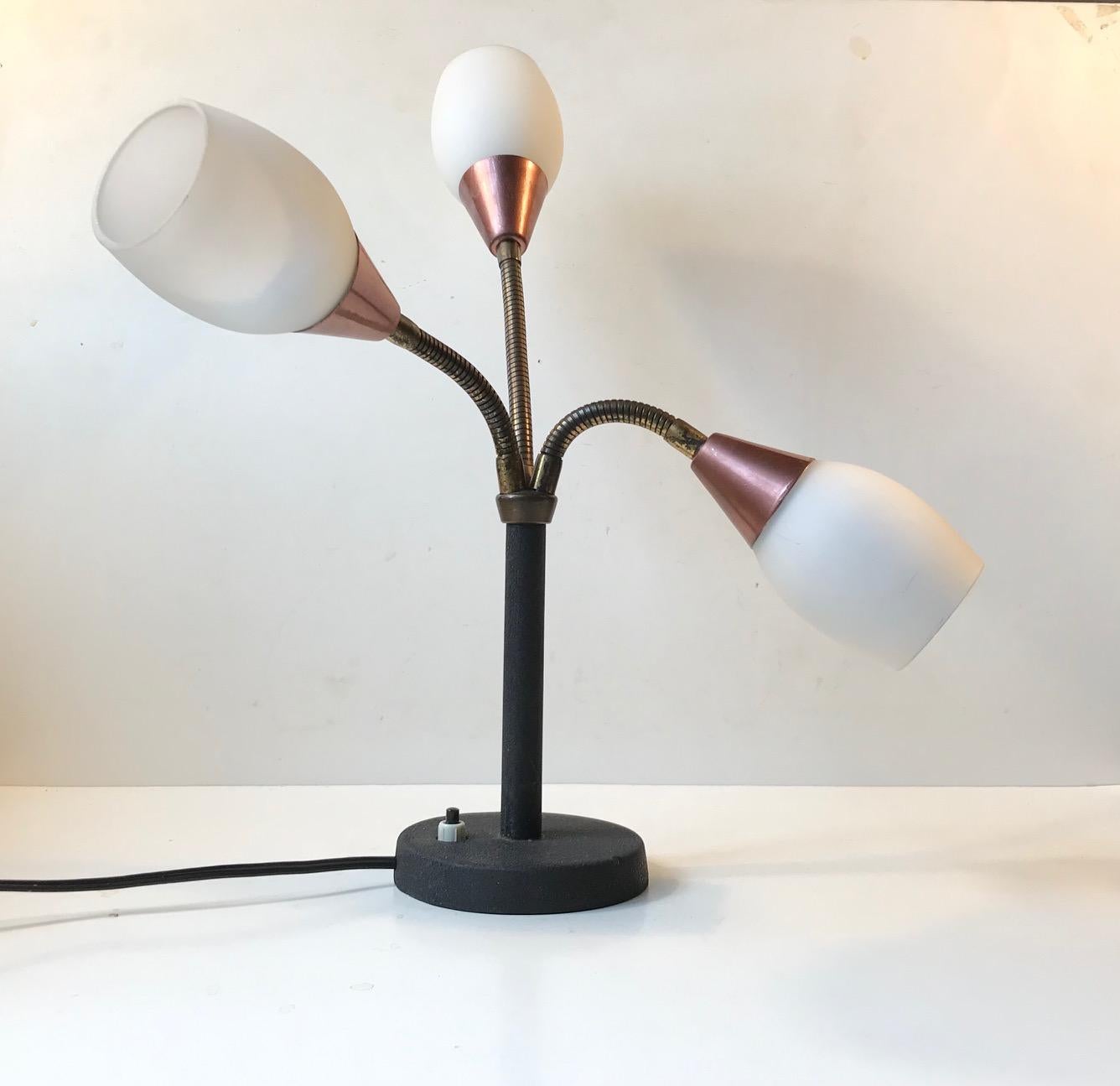 A very rare fully adjustable 3-shaded table or desk lamp. It has opaline glass shades and flexible 'goose' necks' that allows adjustment in every angle. It was manufactured and designed by E. S. Horn in Denmark during the 1950s.