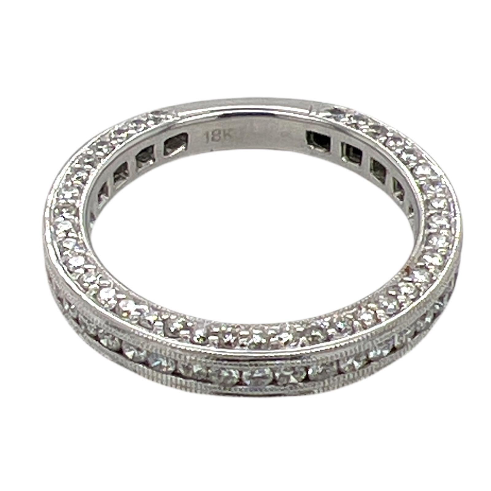 Diamond wedding band fashioned in 18 karat white gold. The ring features round brilliant cut diamonds on three sides of the wedding band weighing .68 carat total weight and graded G-H color and SI clarity. The diamonds are set 3/4 of the way around